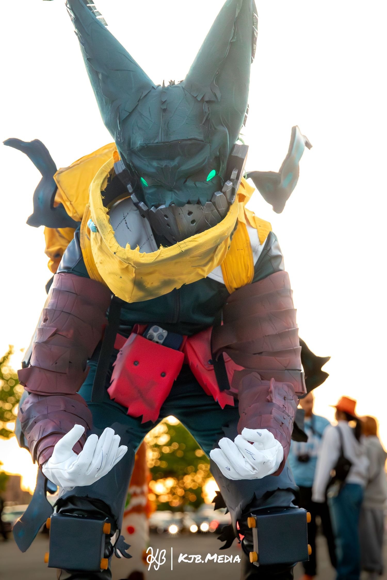 Detailed cosplay of a robot character in yellow armor and mechanical horns photographed from below.