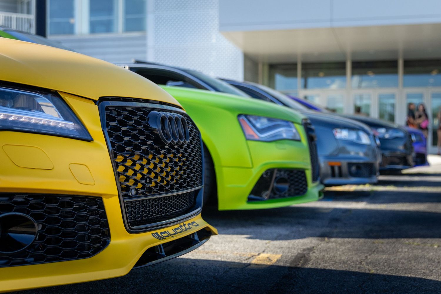 Line of colorful sports cars showcasing front grilles and designs.
