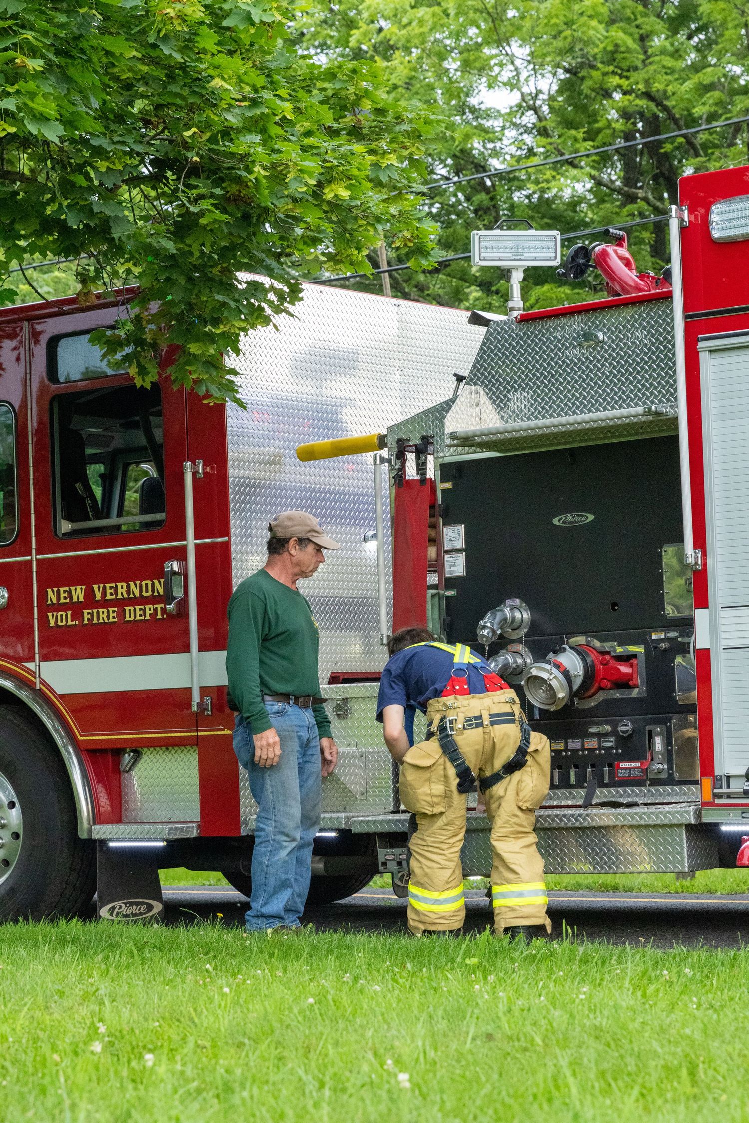 Fire truck and firefighters from New Vernon Fire Department on grassy field.