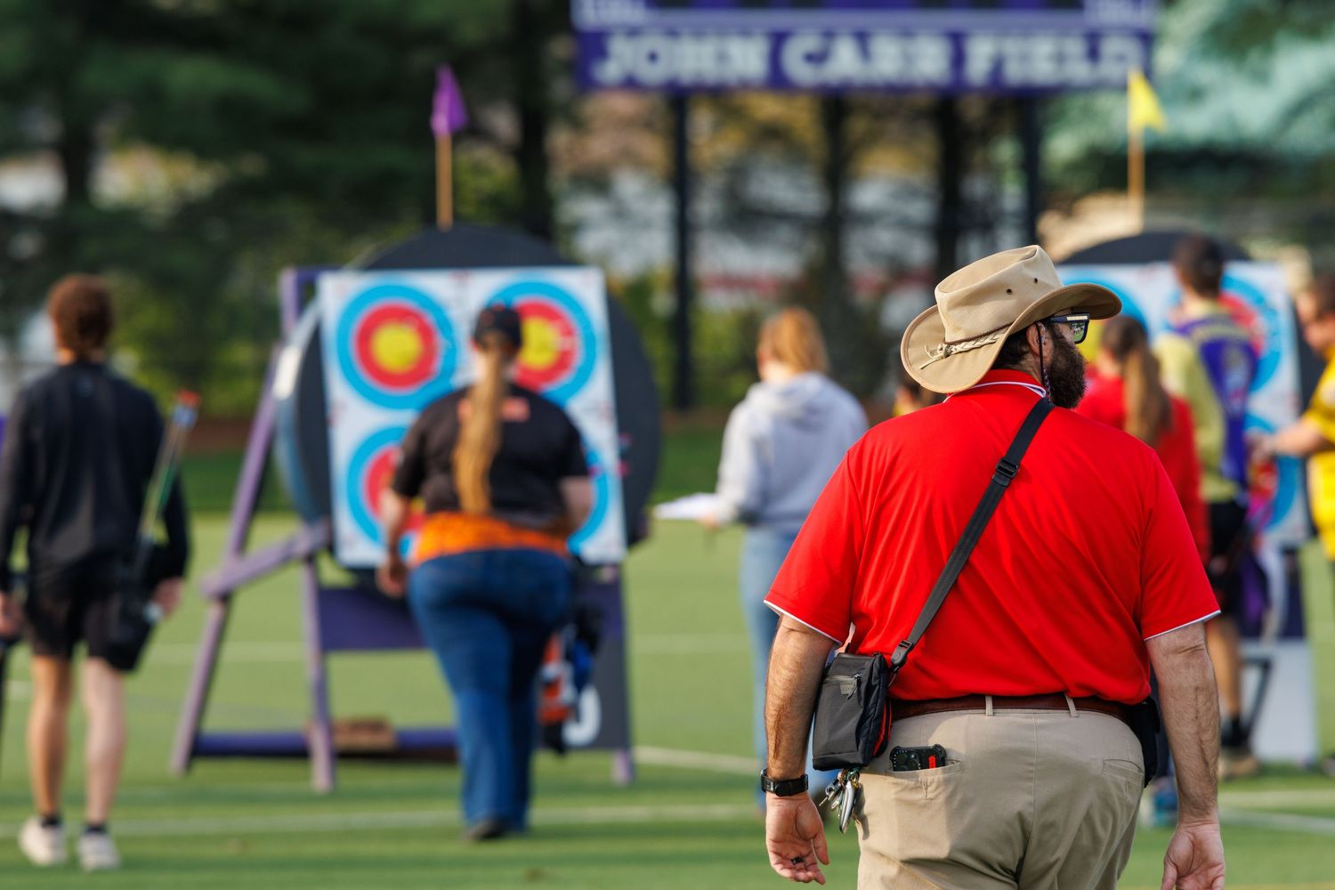 Archery practice at John Carr Field with participants aiming at colorful targets outdoors.