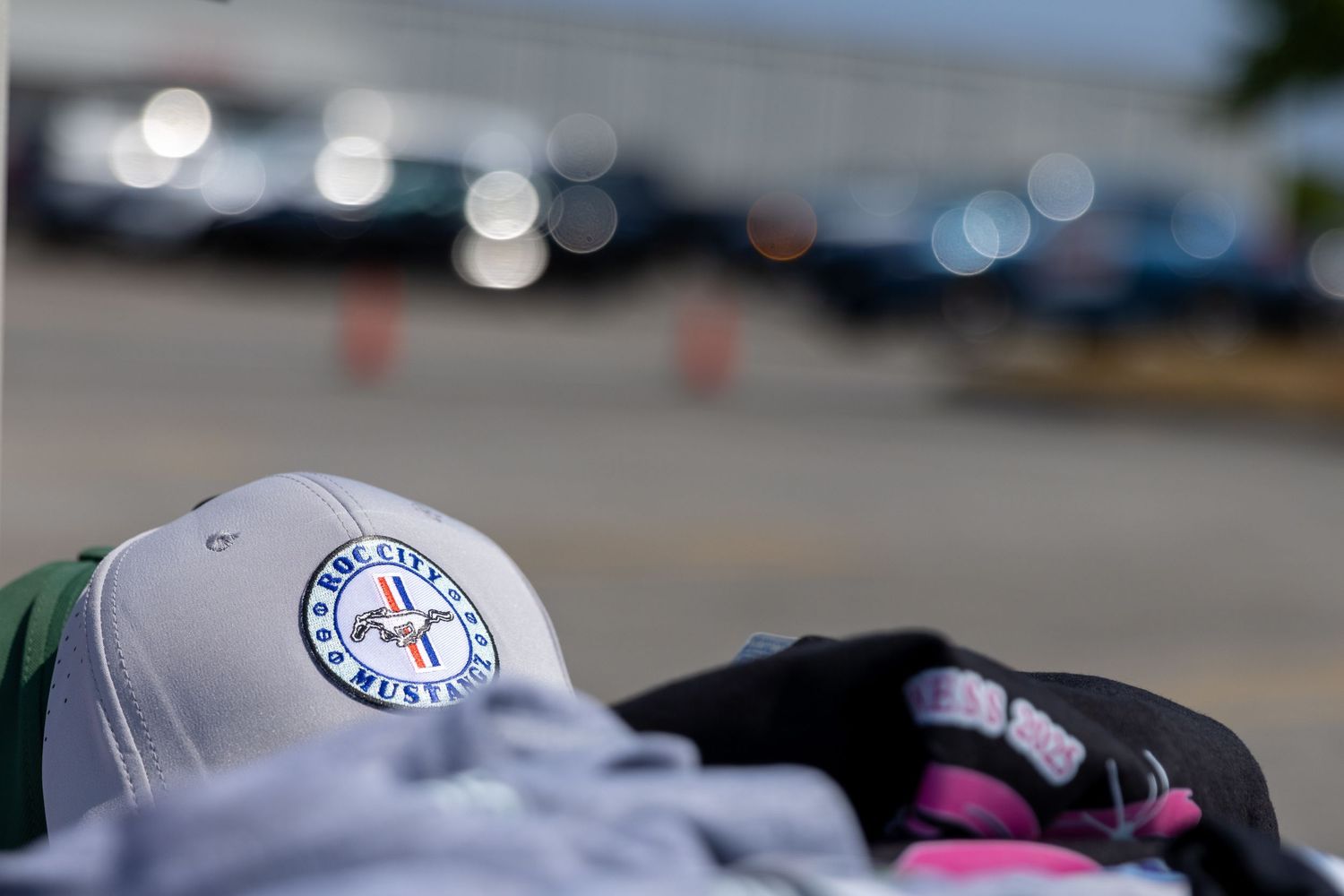 Baseball cap with blue and white team logo in soft focus against blurred background.