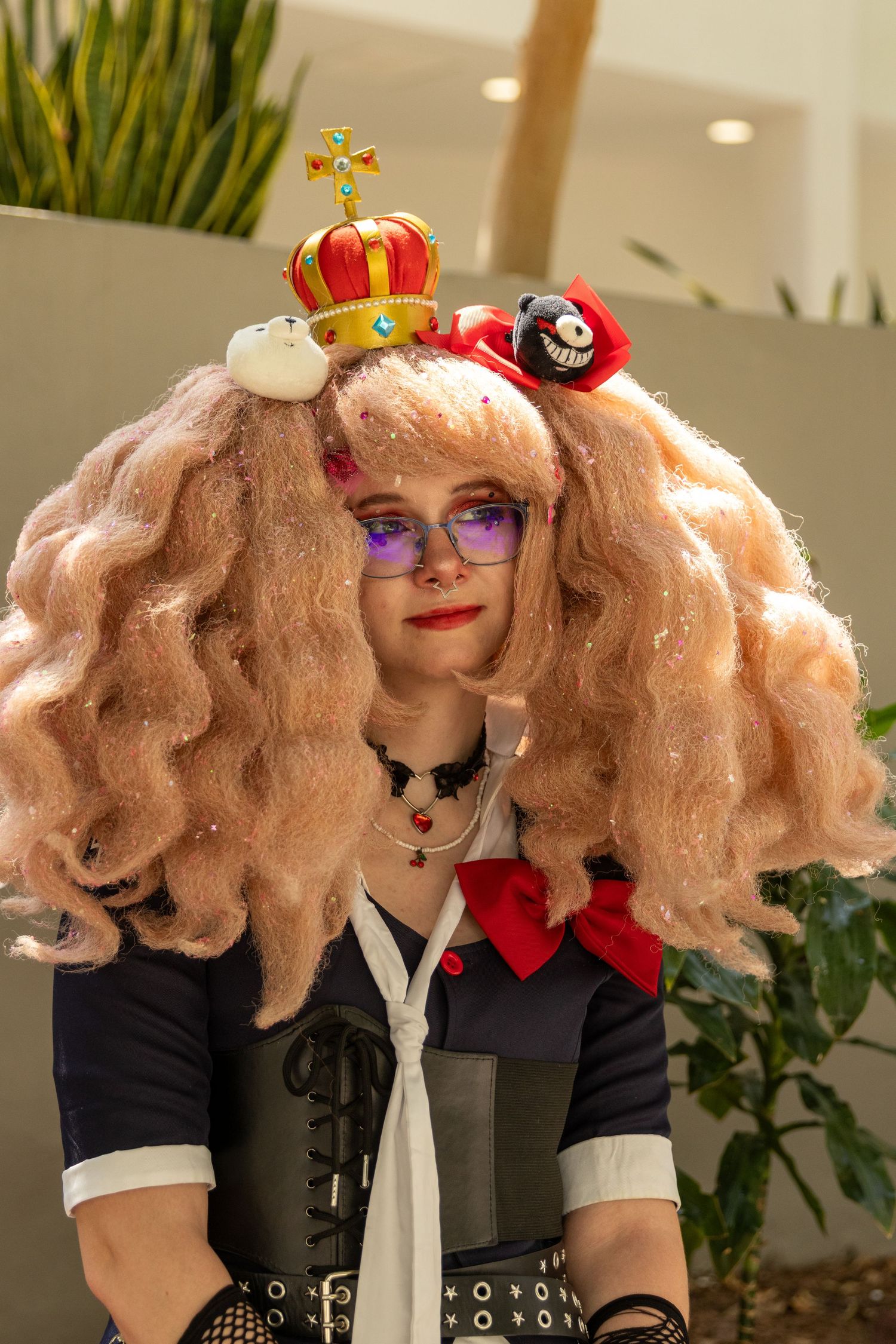 A series of photos showing blonde wavy hair, red lipstick, purple glasses and a crown accessory in a cosplay sequence.