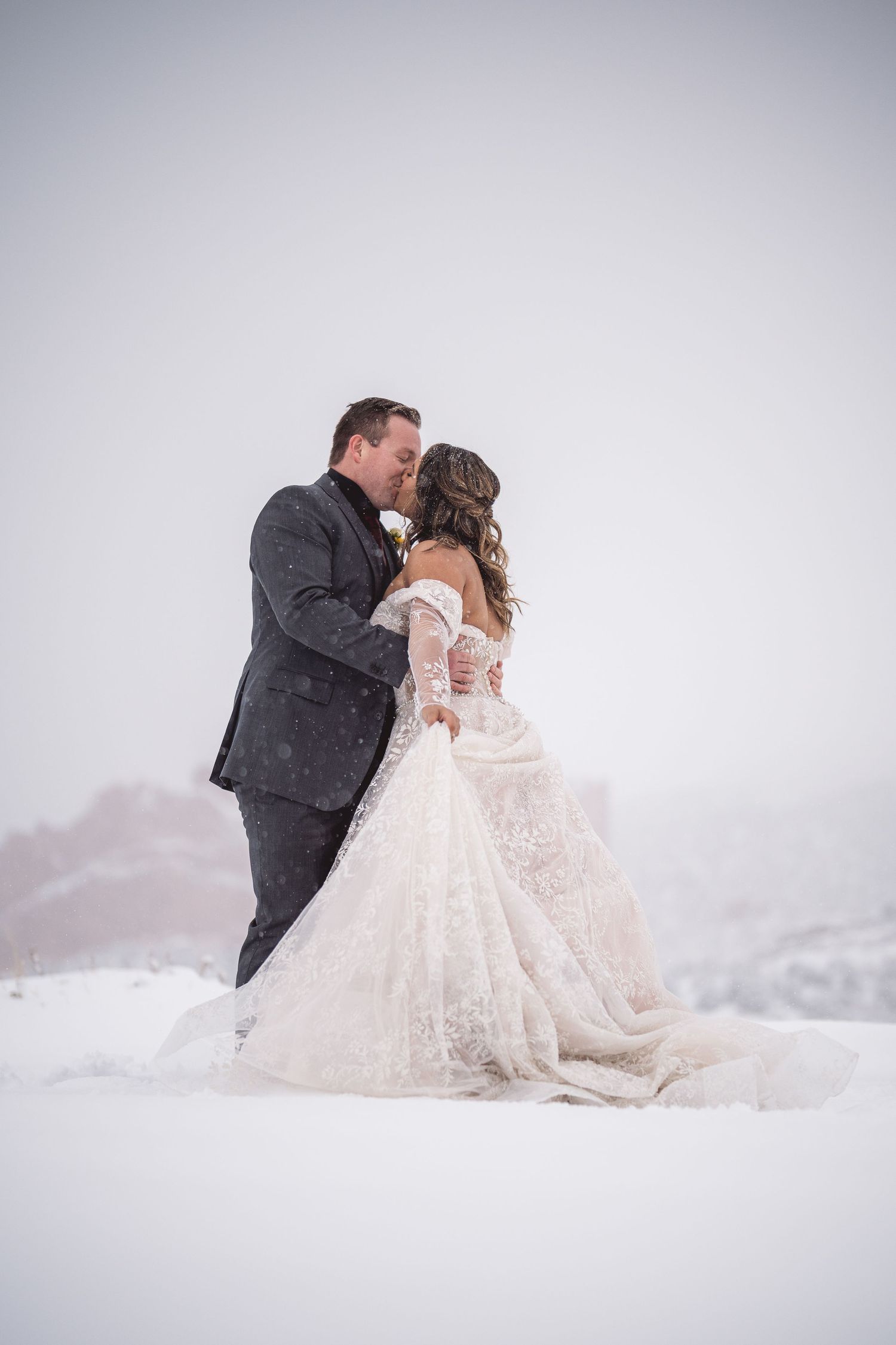 Winter wedding photos showing a couple posing in fresh snow.