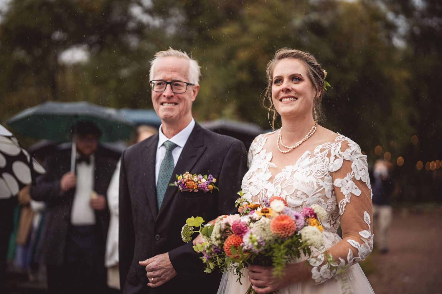 Wedding party proceeds down decorated outdoor path during autumn ceremony.