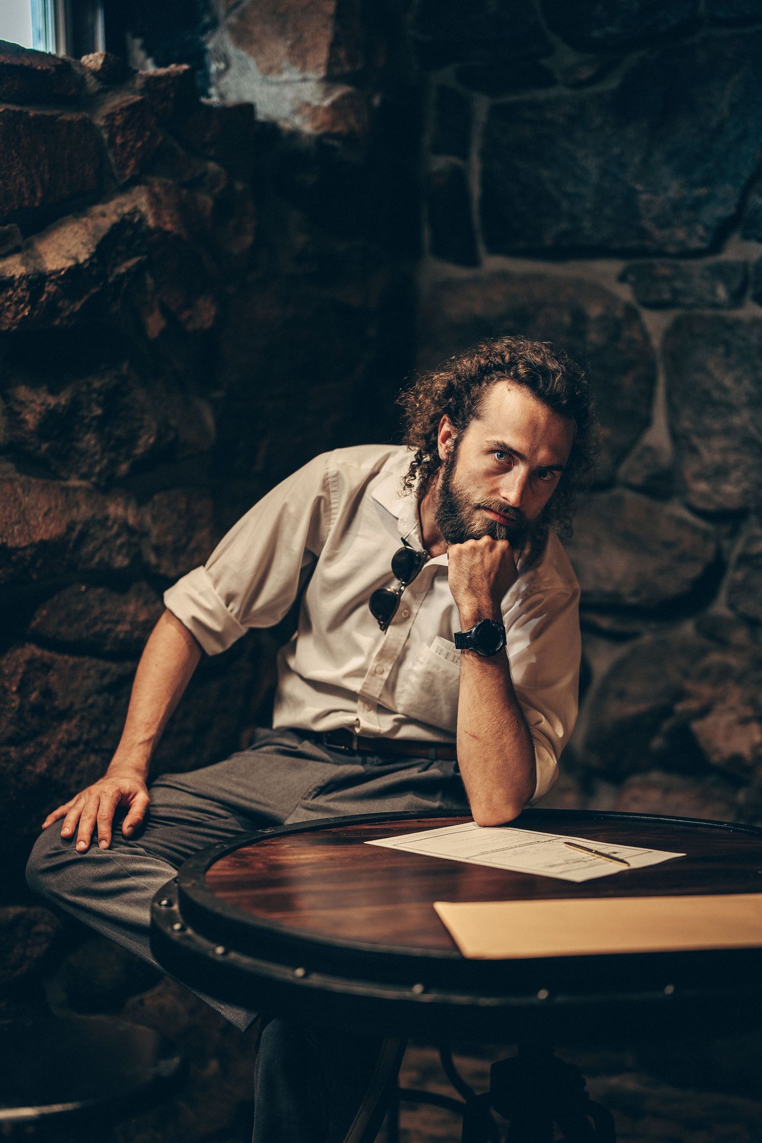 Series of dark moody shots showing someone writing or working at a desk with dramatic lighting.
