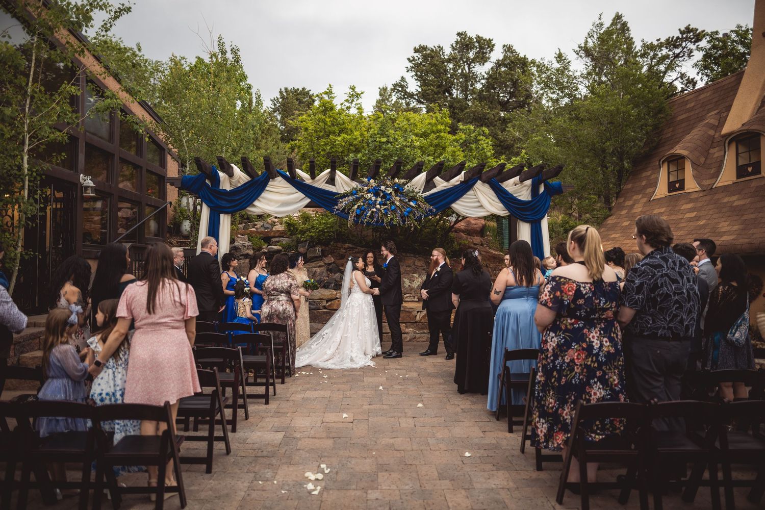 An outdoor wedding ceremony venue with wooden chairs arranged in rows on a stone patio.