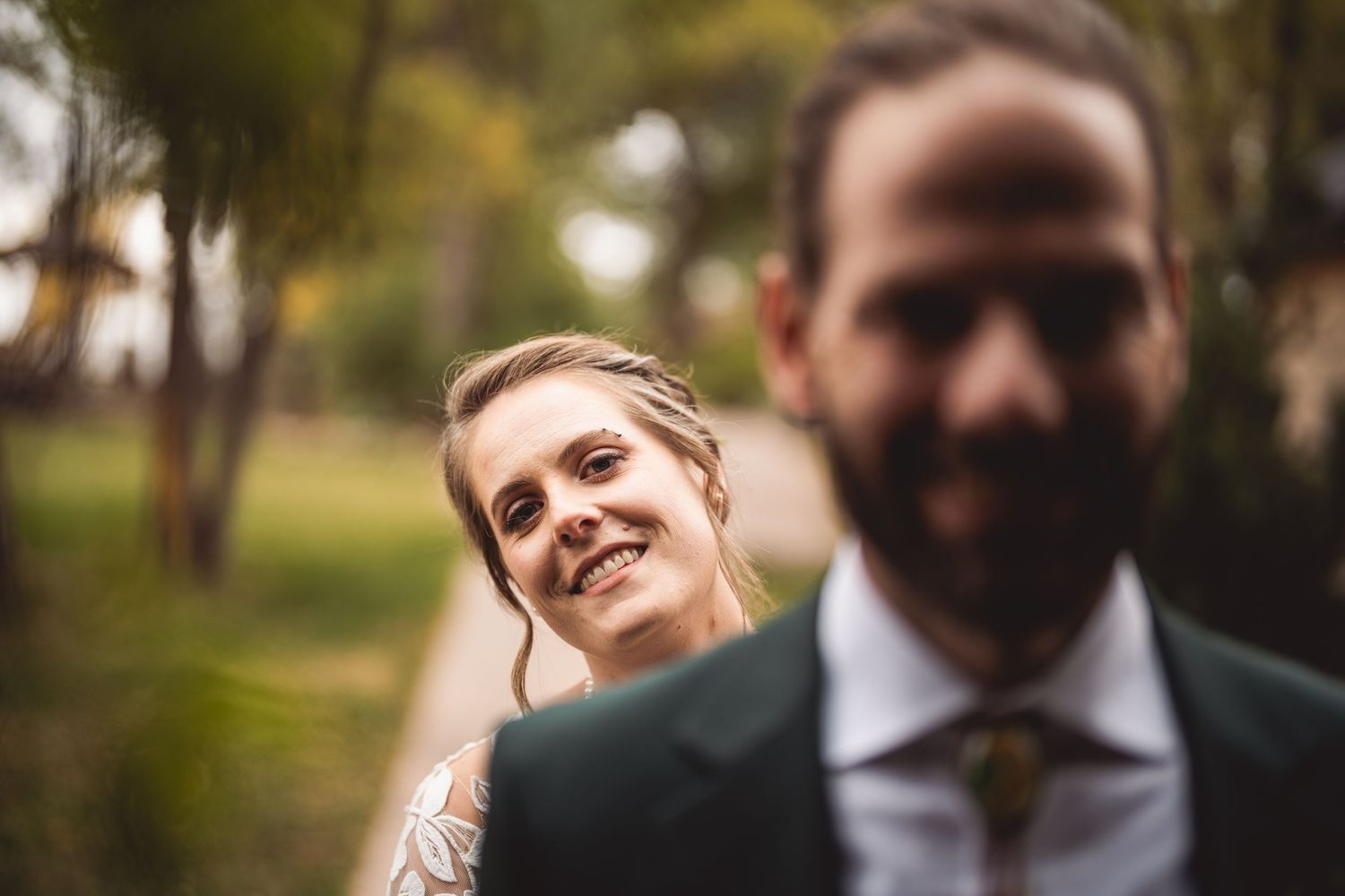 Couple shares intimate first look moment outdoors surrounded by autumn trees.