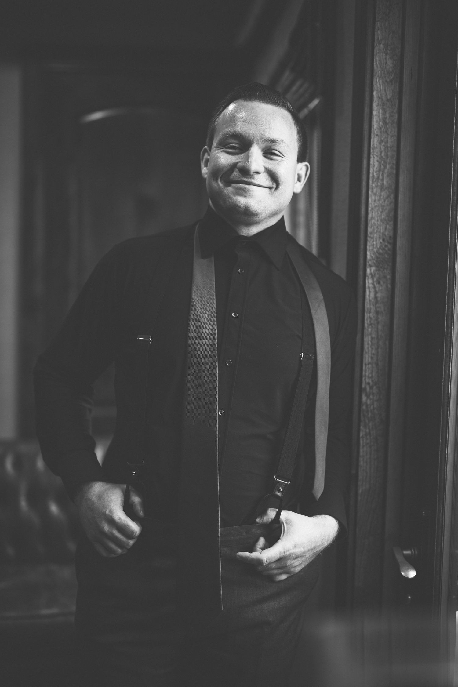 Black and white portrait of someone in formal attire with dramatic lighting.