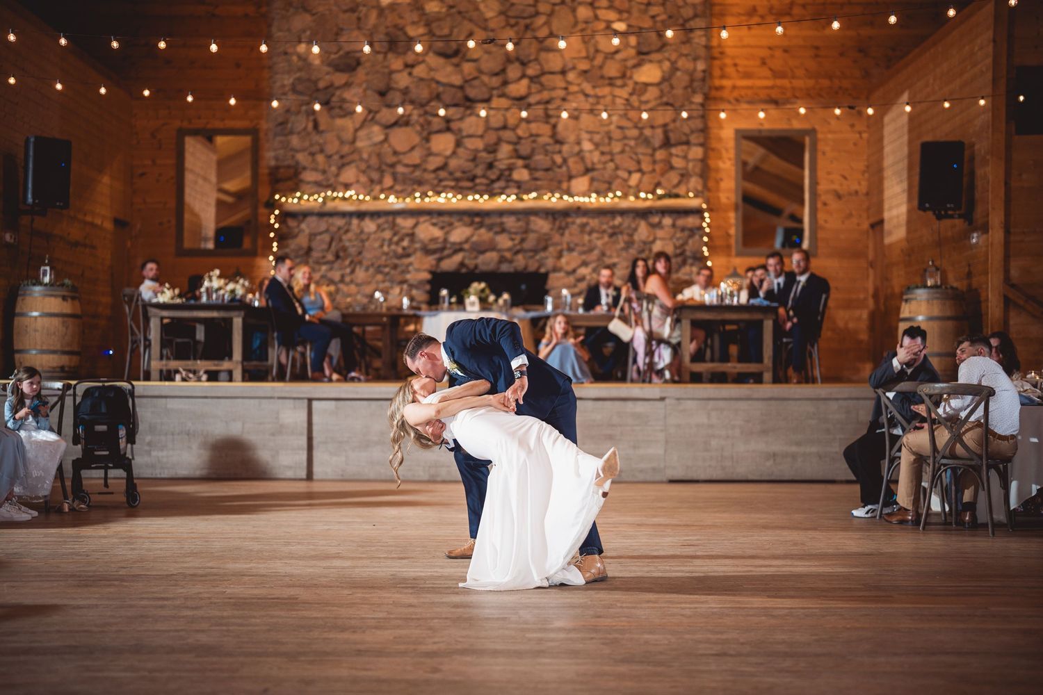 Wedding dance floor sequence in a rustic barn with string lighting.
