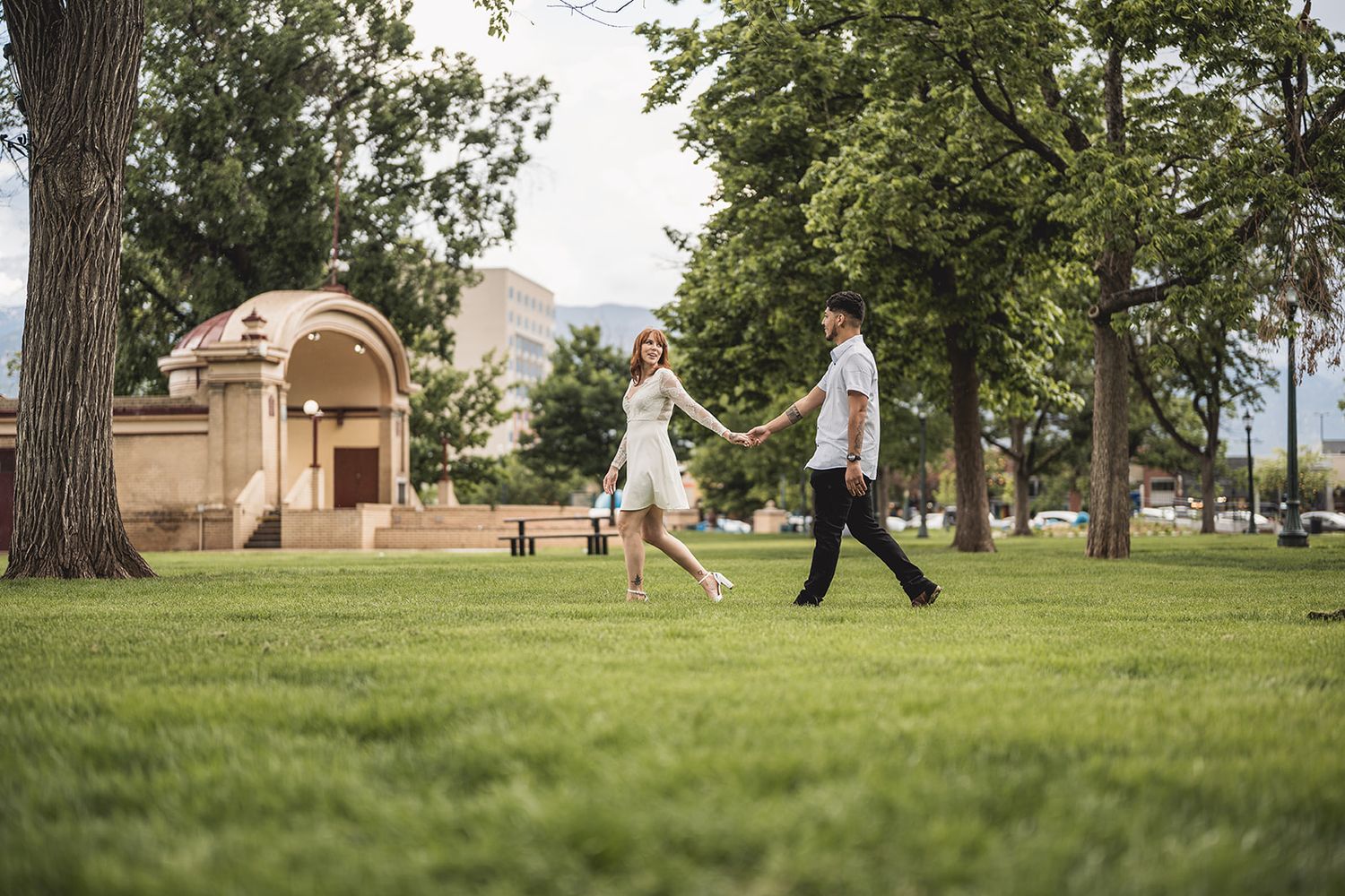 People enjoying leisure time on a grassy lawn in an urban park setting.