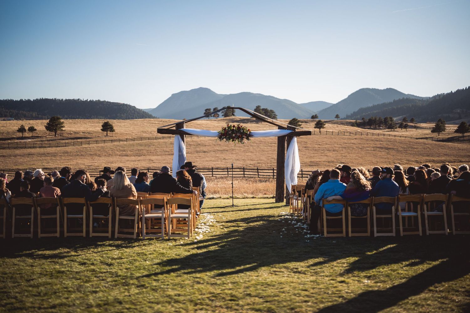 Mountain landscape with wooden benches arranged for outdoor ceremony.