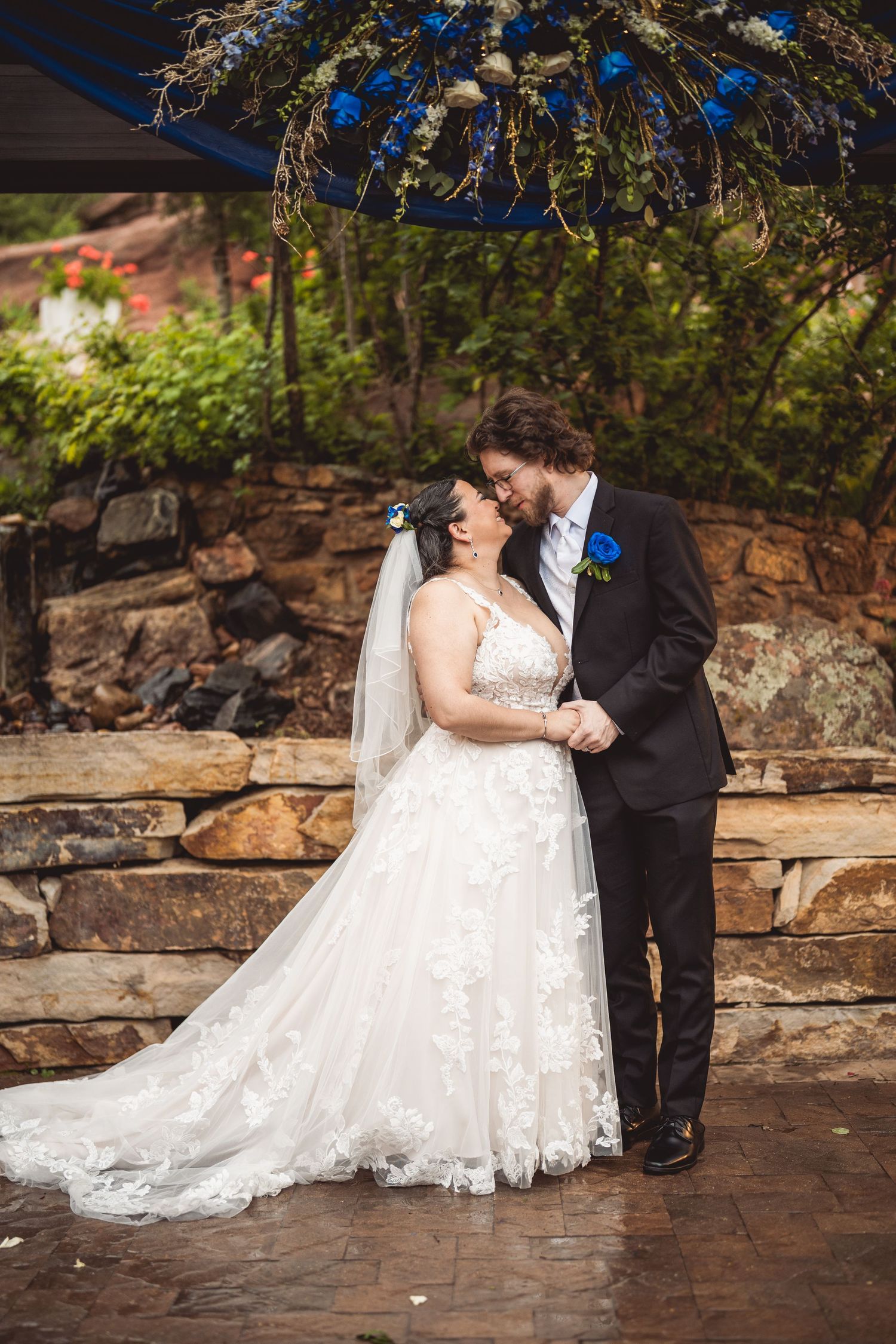 A couple sharing a tender moment on stone steps during their mountain wedding.