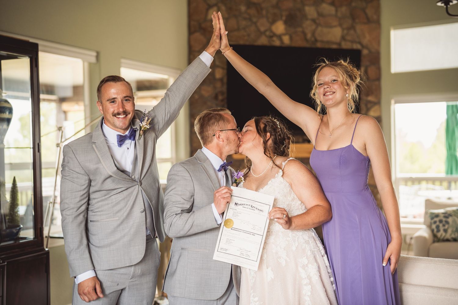 Wedding party gathered together wearing purple and gray attire.