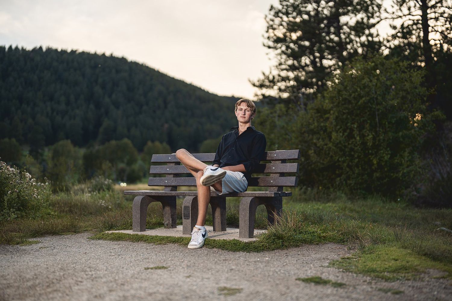 Wooden benches on a mountain overlook during sunset.