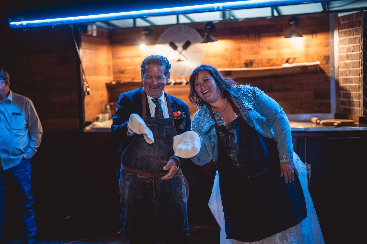 Wedding celebration at a rustic venue with blue accent lighting and wooden bar.