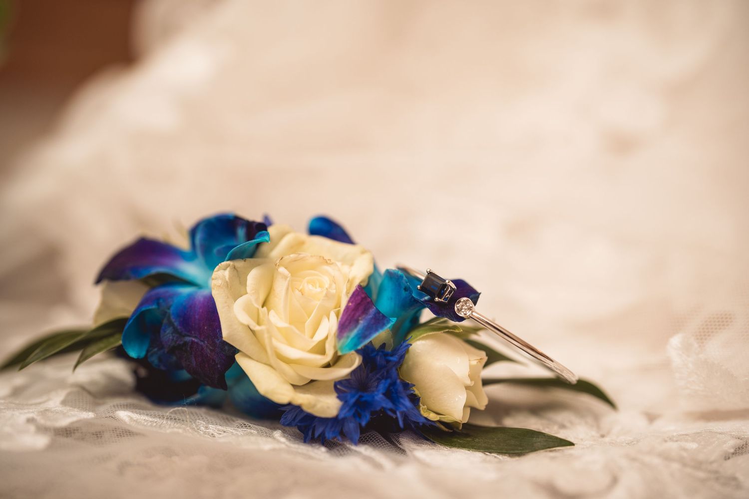 Yellow roses paired with vibrant blue orchids create a striking wedding bouquet detail.