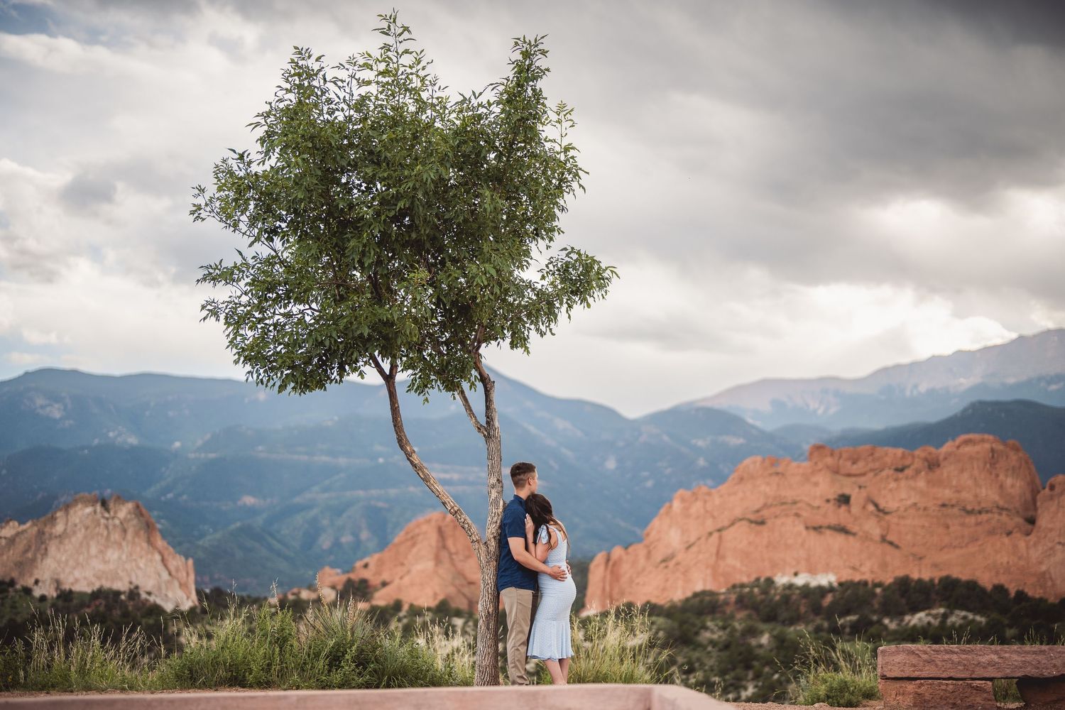 A scenic portrait at Garden of the Gods with red rocks and mountains creating a dramatic backdrop.