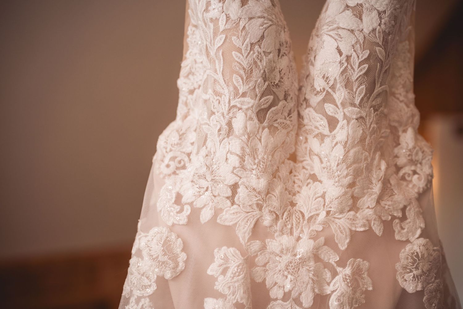Close-up detail shot of delicate white lace pattern on a wedding dress.