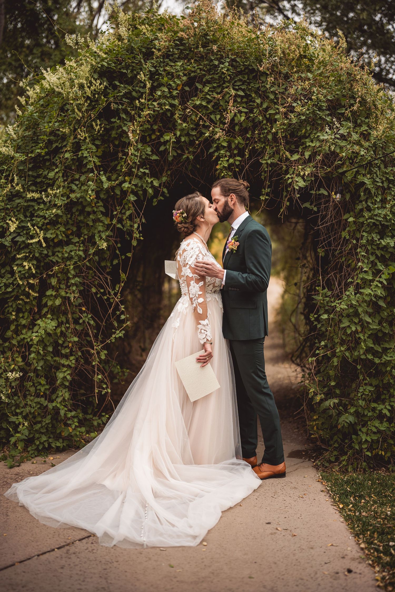 A romantic first look sequence between newlyweds in a garden setting with flowing white wedding dress and dark suit.