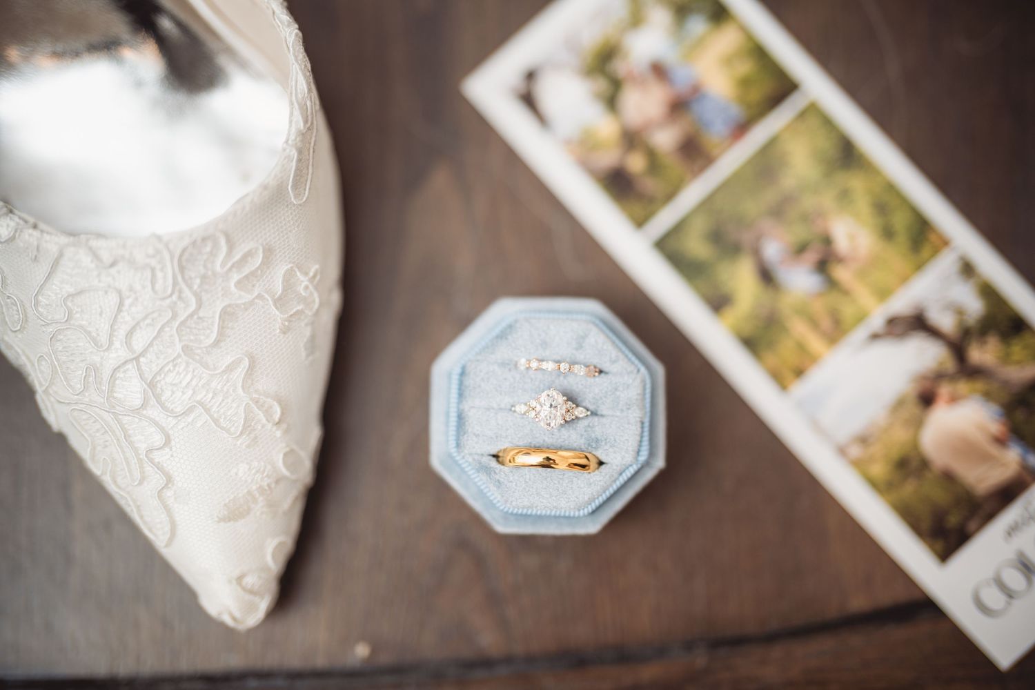 Wedding accessories and photographs arranged artistically on dark wooden surface.
