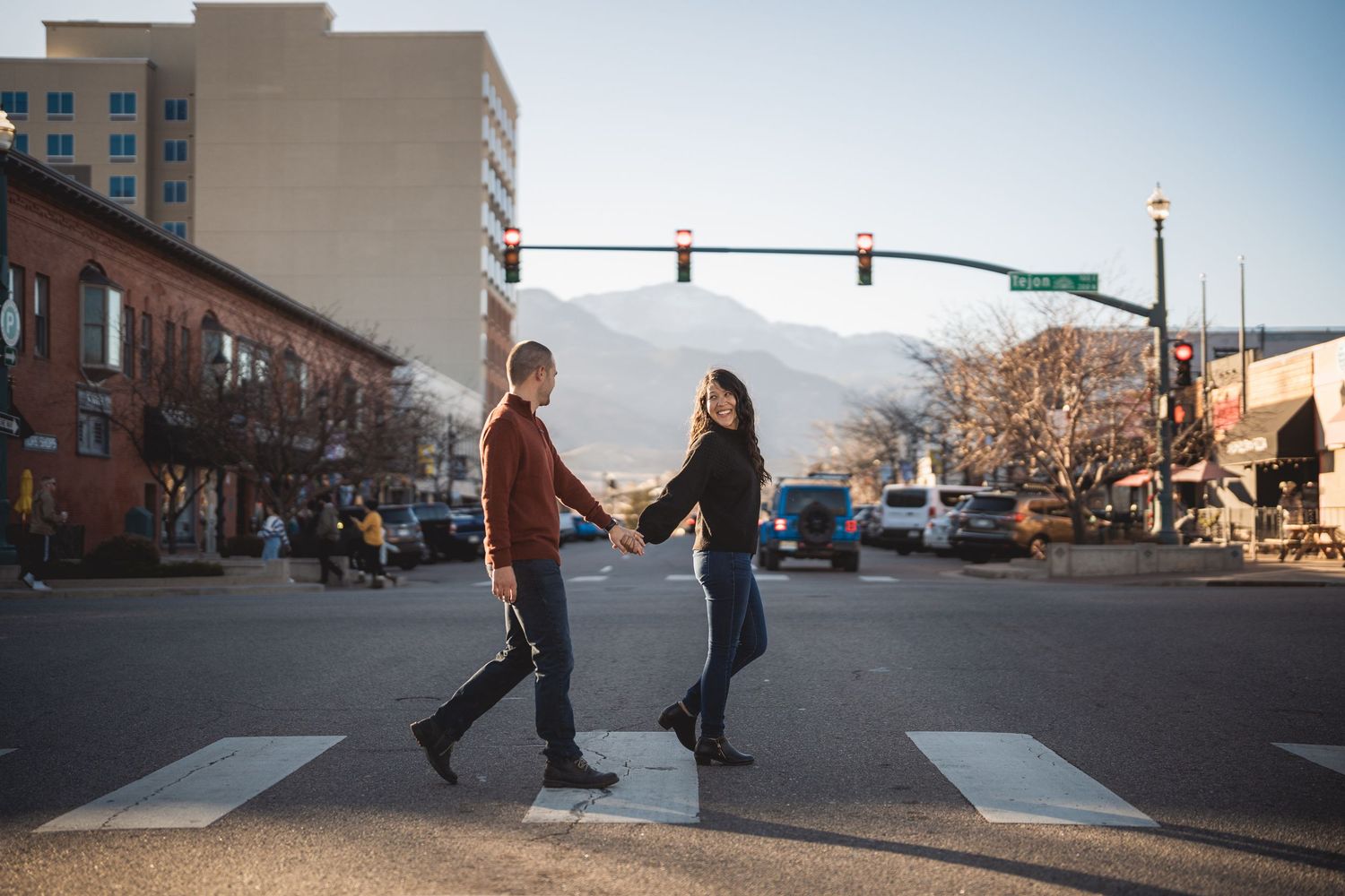 People walking on urban sidewalk with brick buildings in background during daytime.