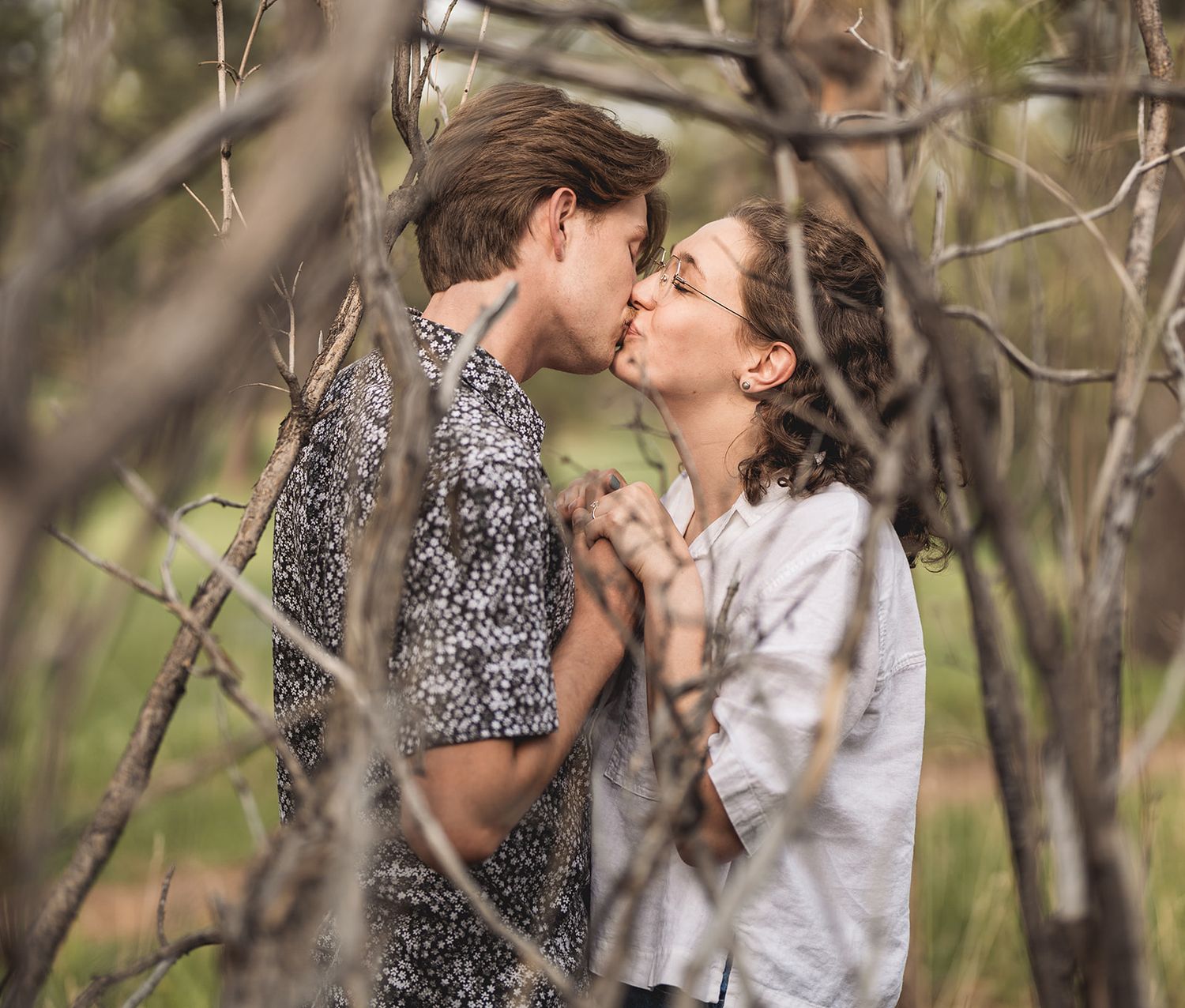 Romantic spring portrait session among blooming yellow flowers and natural foliage.