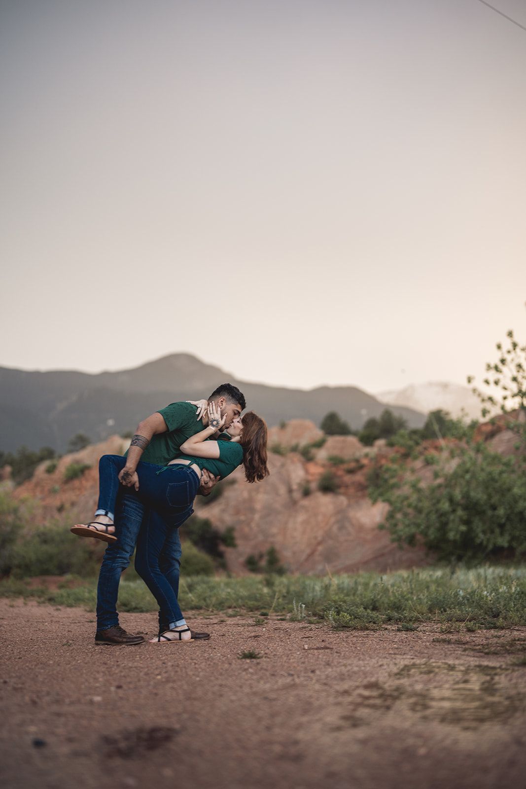 Playful engagement photo sequence showing couple bending down in a desert landscape at sunset.