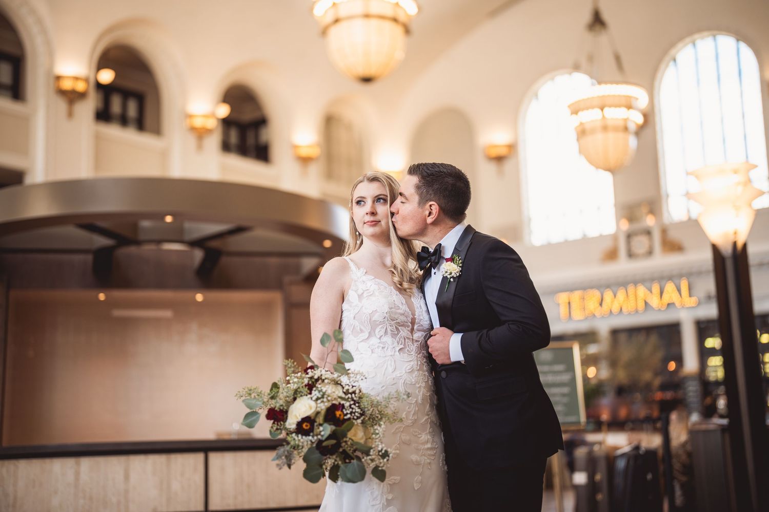 Elegant wedding venue interior with arched windows and classic lighting fixtures.