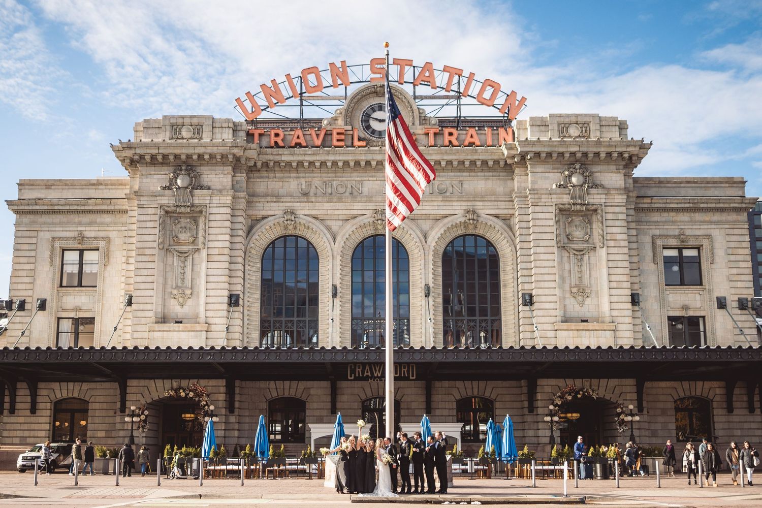 Wedding party poses in front of historic Union Station Travel by Train building in Denver, Colorado.