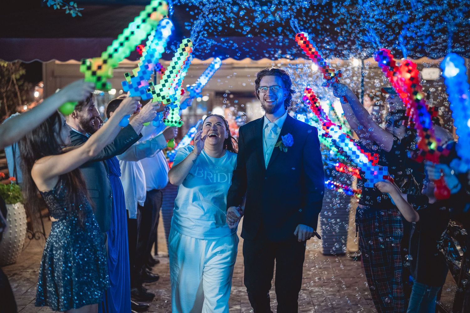 Wedding reception dance floor illuminated with blue LED lights and party guests.