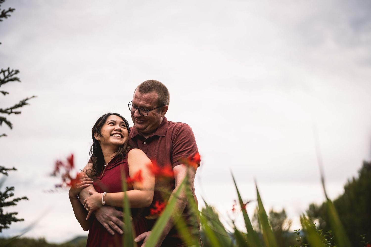 Candid laughter shared during a joyful outdoor photoshoot with natural lighting.