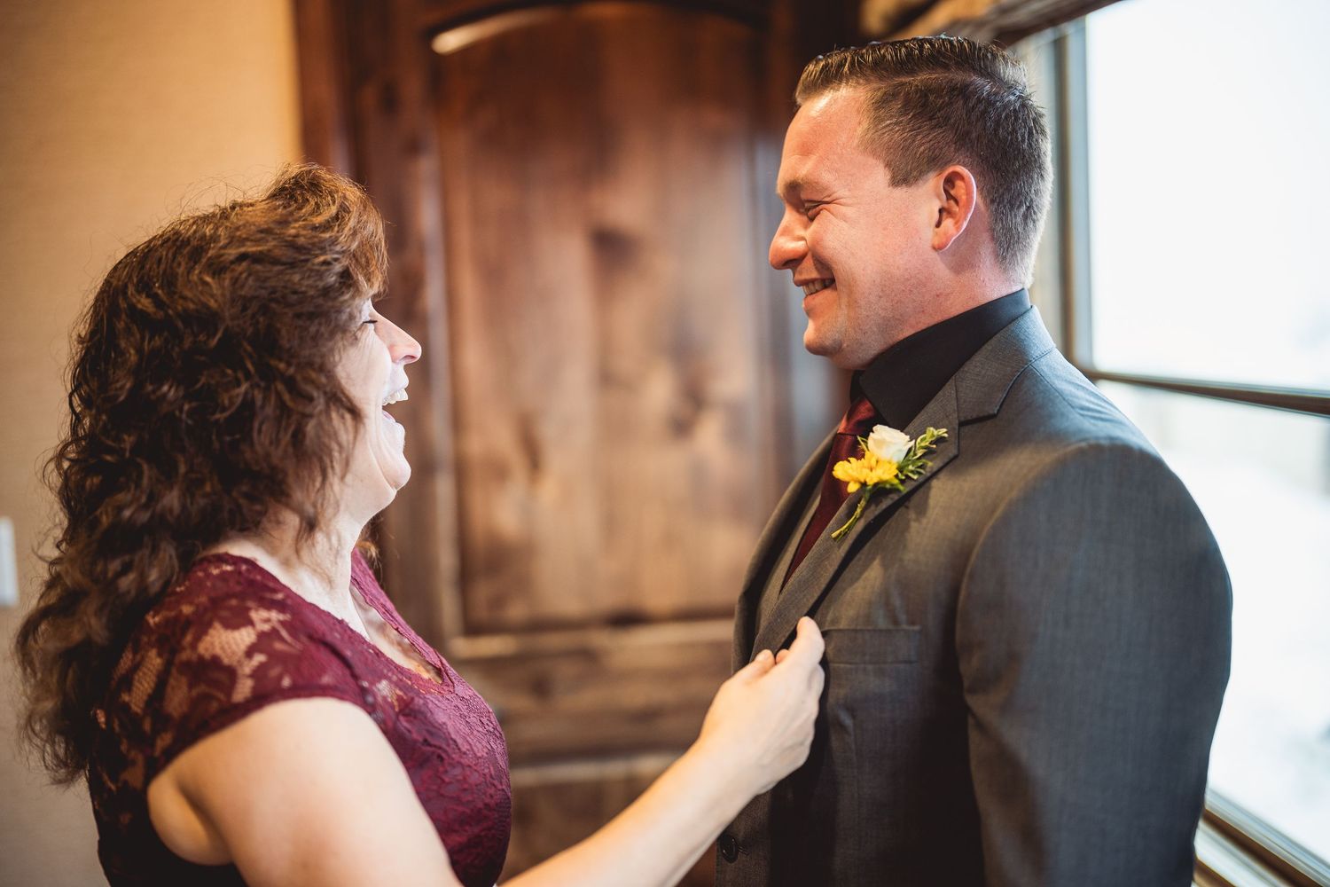 A couple sharing an intimate laughing moment at their wedding reception.