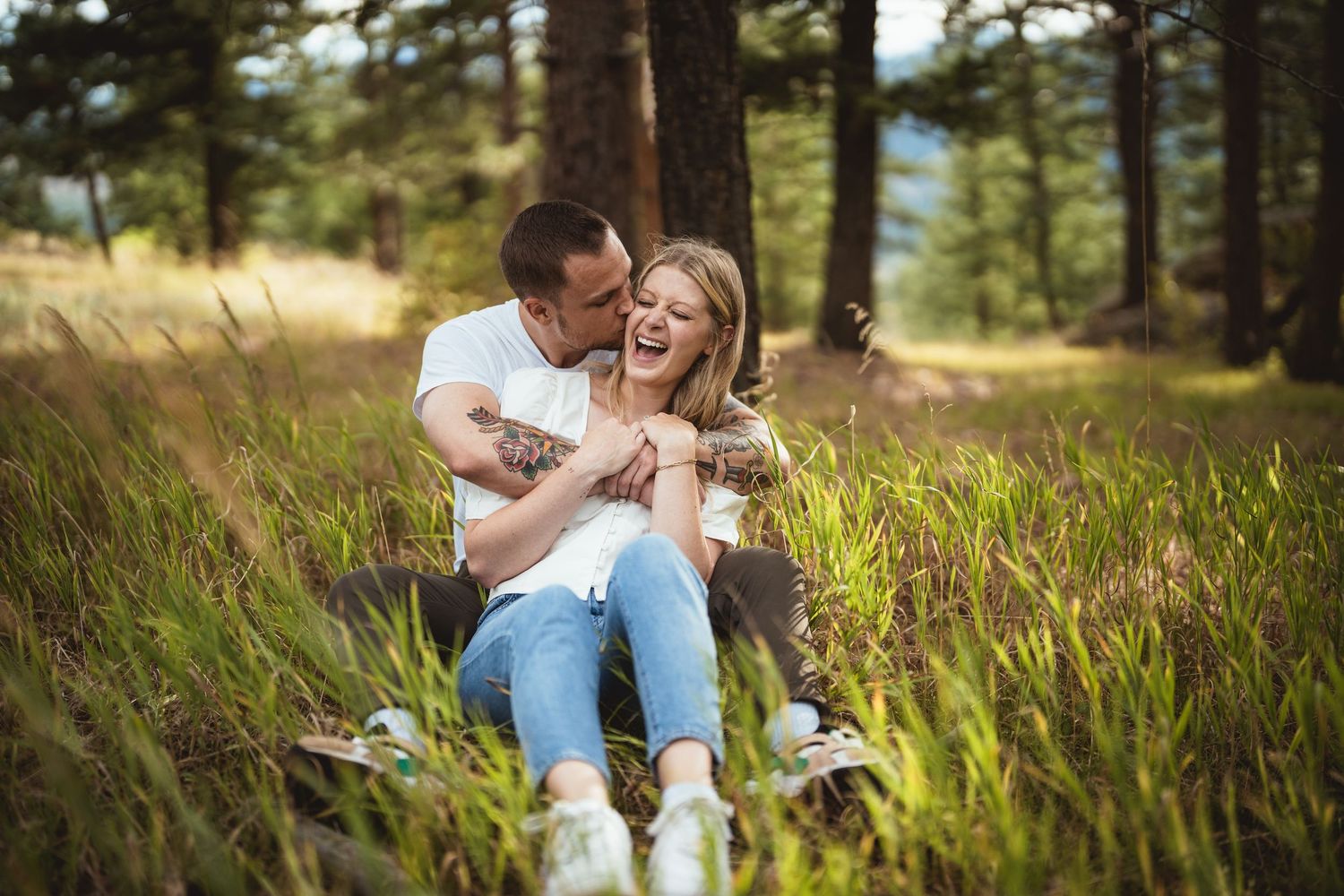 Romantic outdoor photoshoot among tall pine trees and natural landscape.