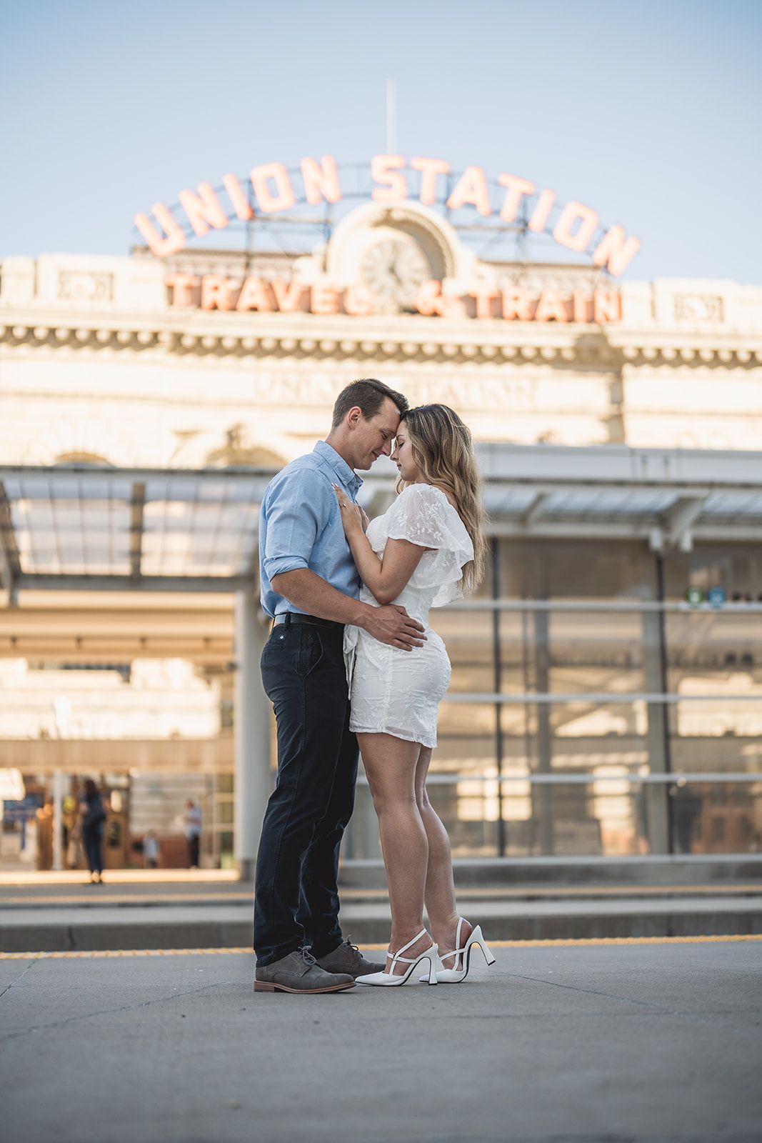Romantic moment captured in front of illuminated Union Station facade at dusk.