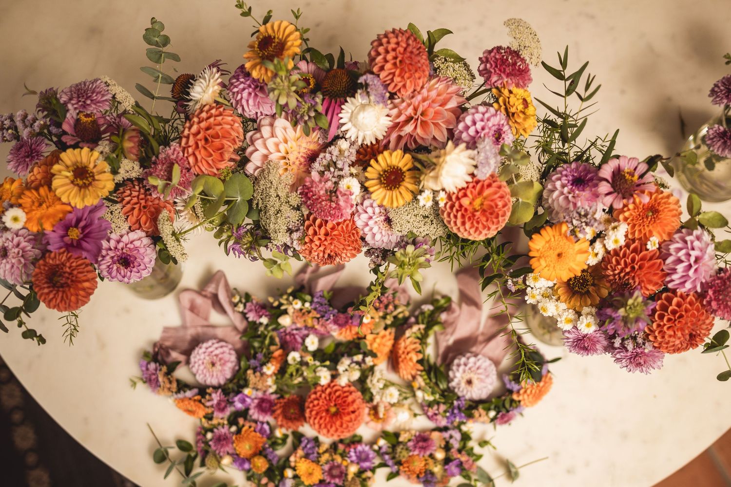 Colorful floral arrangement featuring sunflowers, dahlias, and mixed blooms in warm autumn colors.