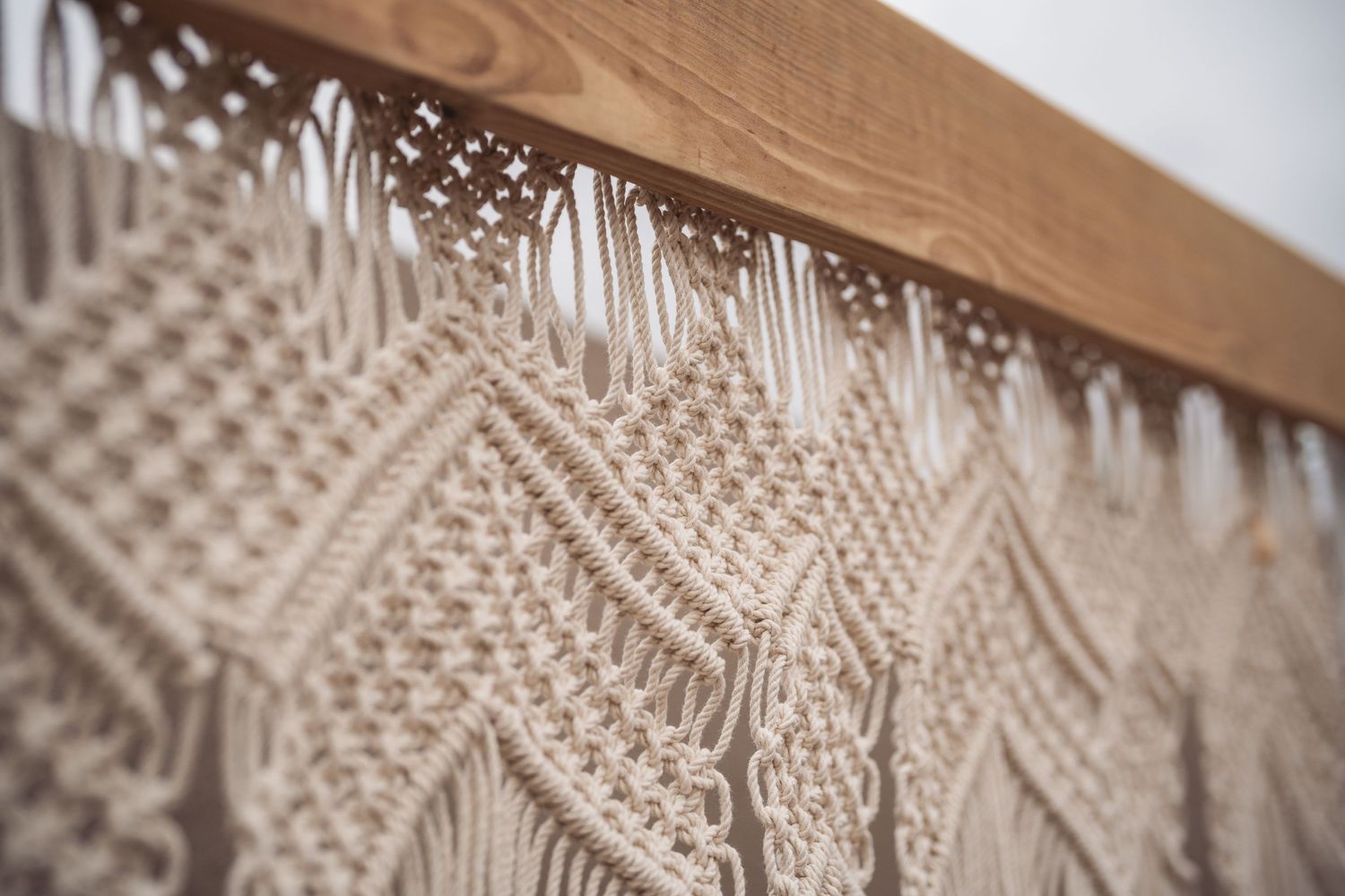 Close-up detail of intricate macrame wedding backdrop with geometric patterns.