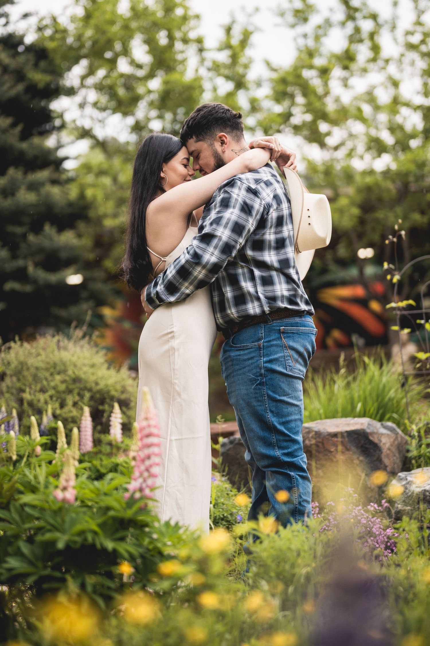Dancing couple in a garden with blooming flowers and fluttering butterflies.