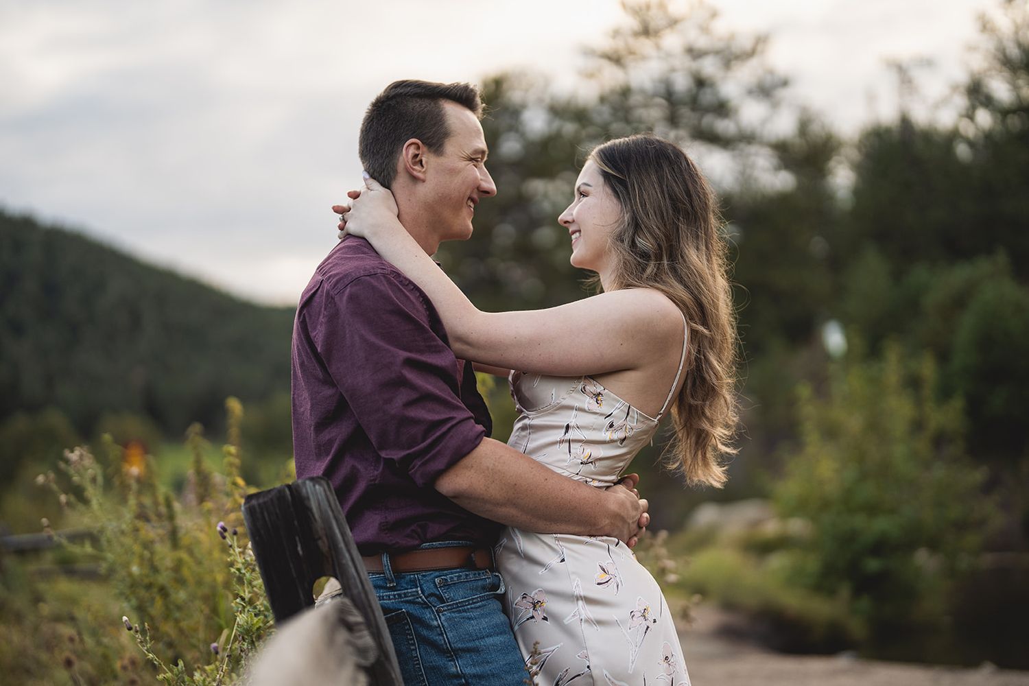 Outdoor engagement session in mountain setting with warm evening light and natural scenery.