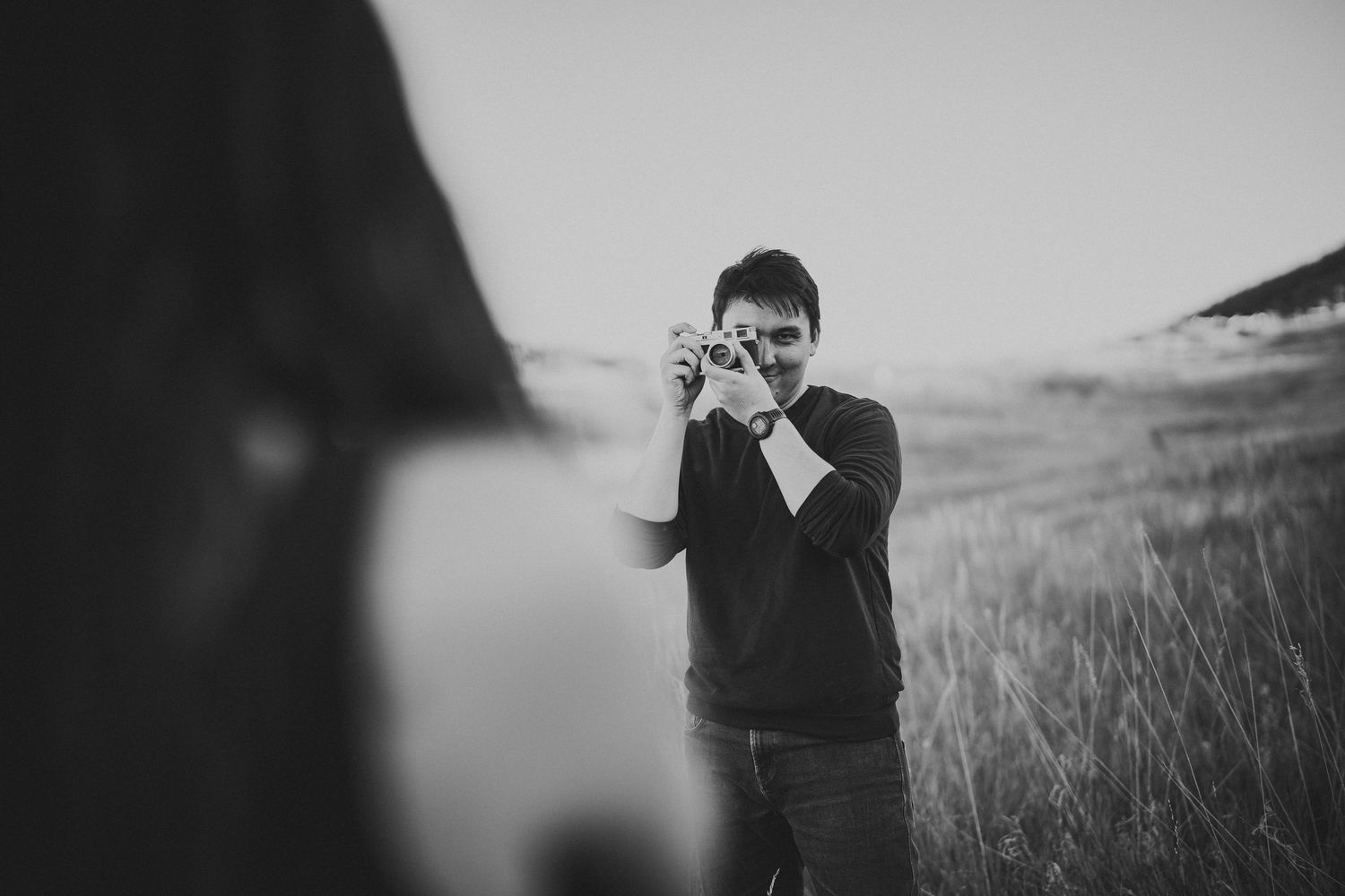 Dramatic black and white silhouettes against a moody outdoor landscape.