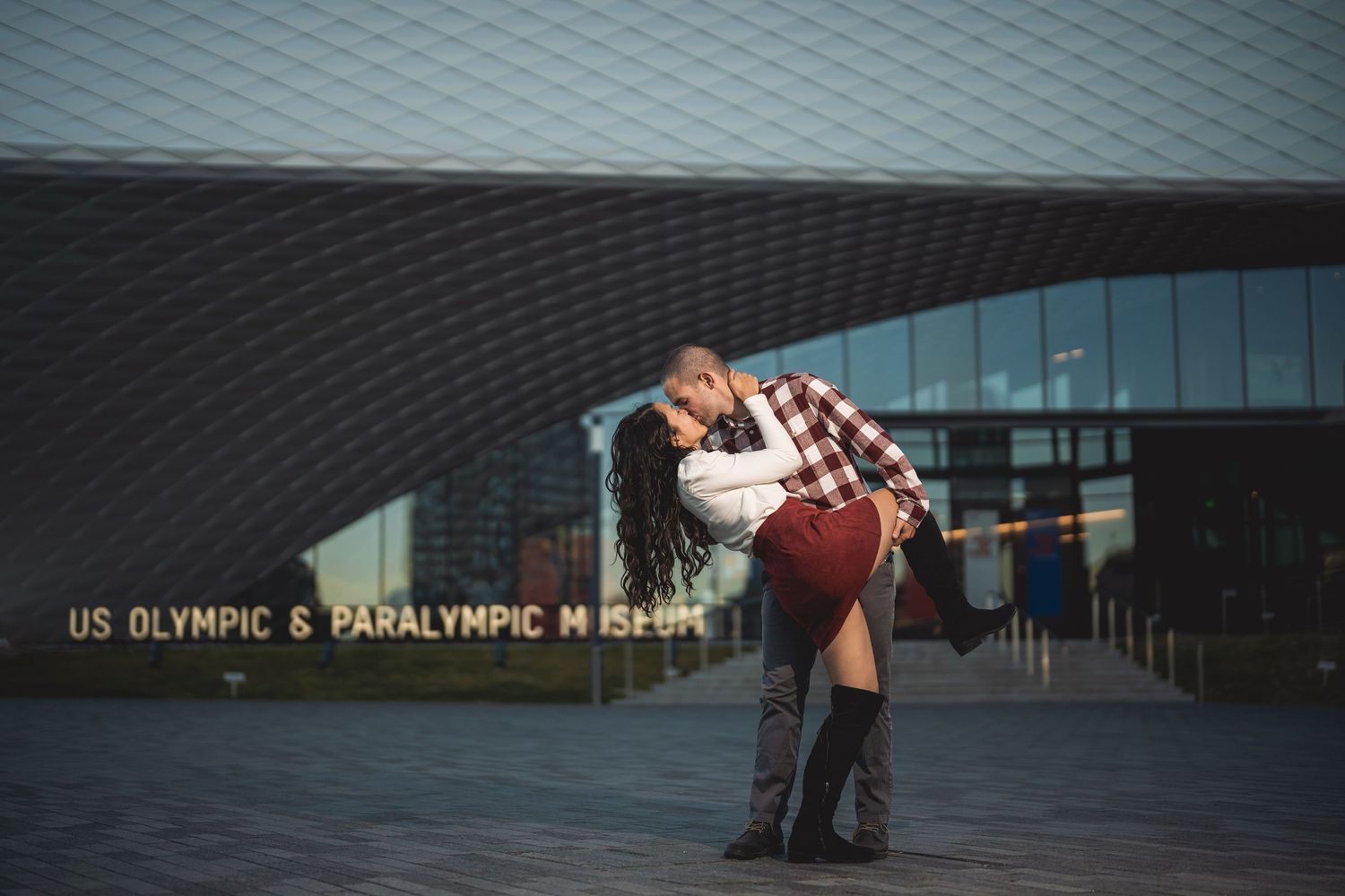 Couple silhouetted against modern architectural background with geometric patterns.