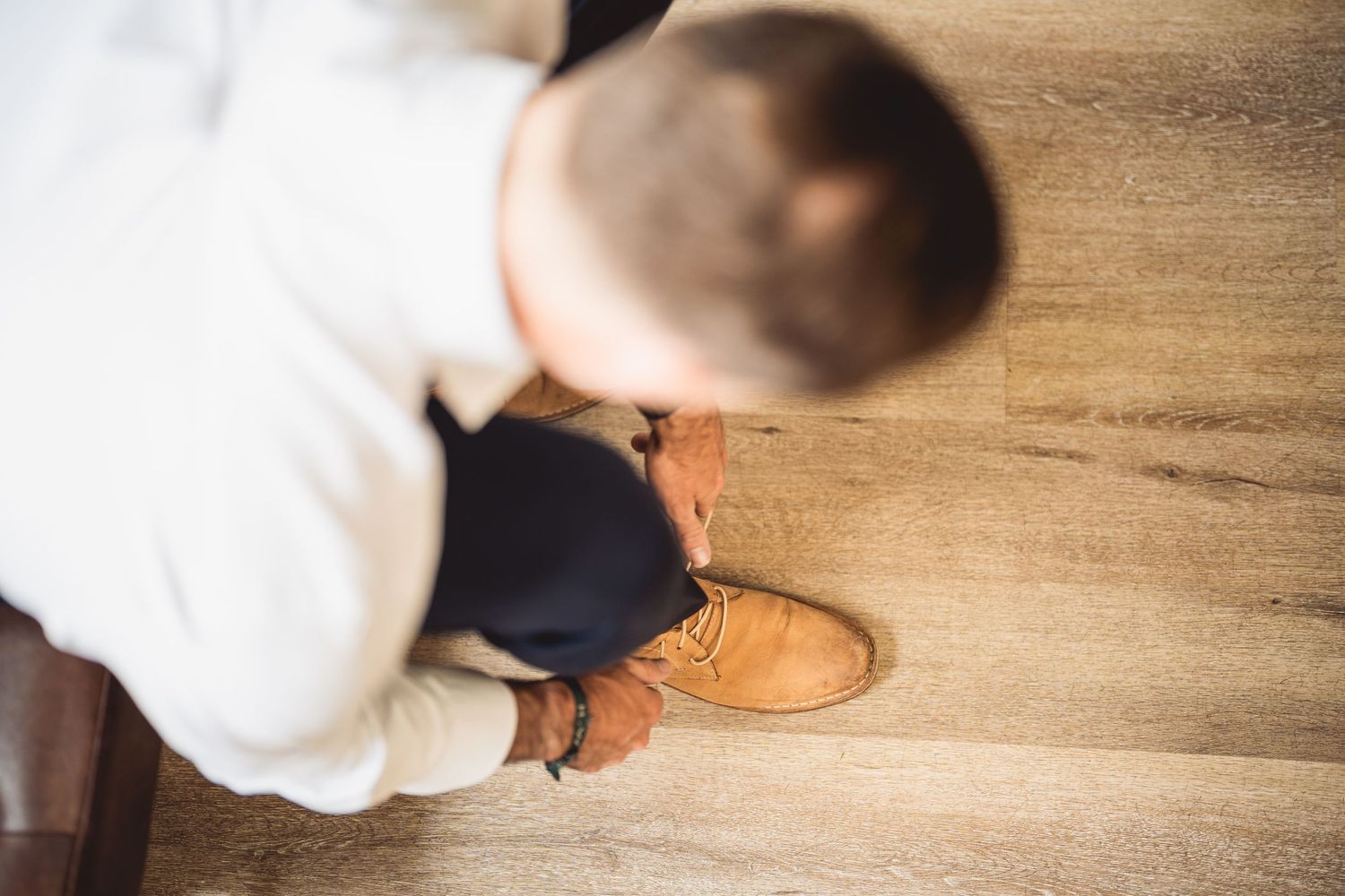 Overhead view of brown leather dress shoes on wooden flooring.