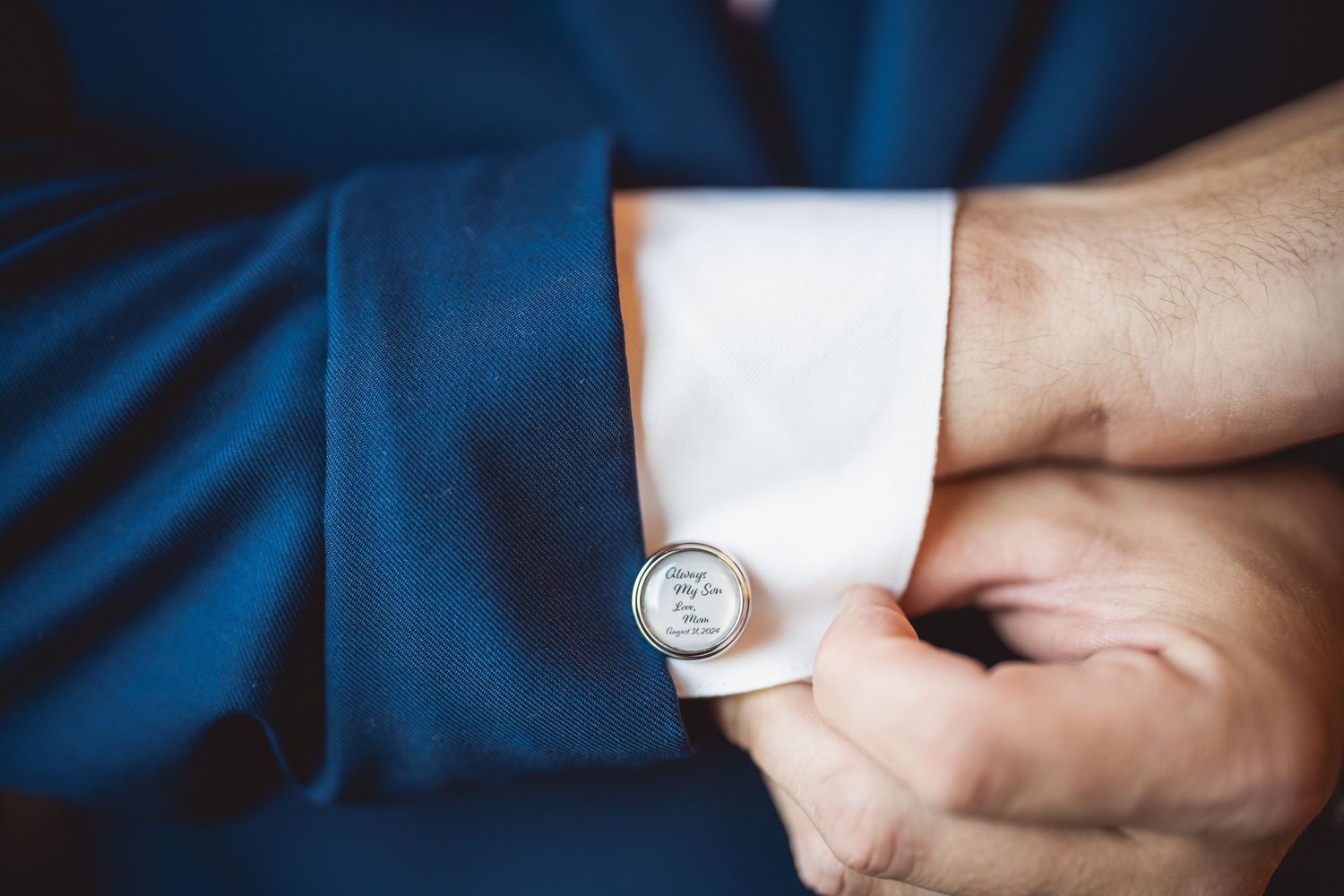Close-up shots of adjusting white dress shirt cuffs and cufflinks against blue fabric background.