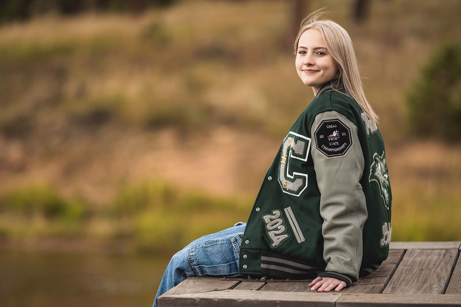 Casual outdoor portrait session on wooden bench in forest setting.