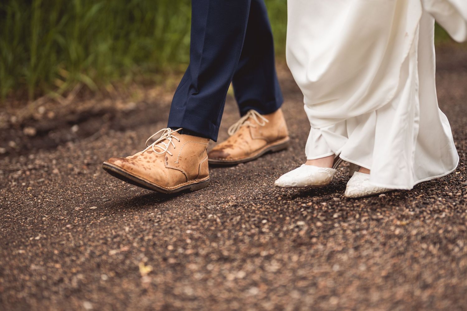Detail shot of wedding couple's shoes on a gravel path during their photoshoot.