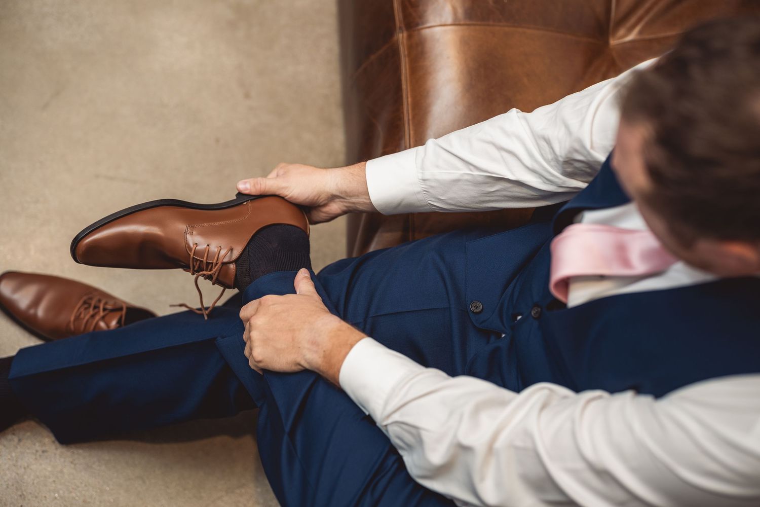 Detail shot of brown leather dress shoes on hardwood floor.