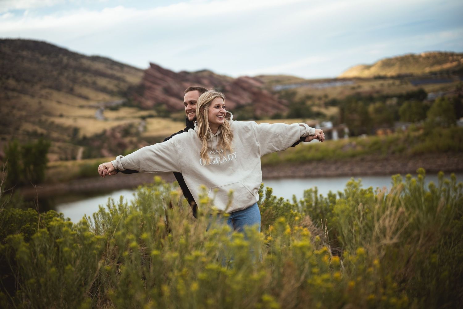Mountain landscape photography with lake and rolling hills in background.