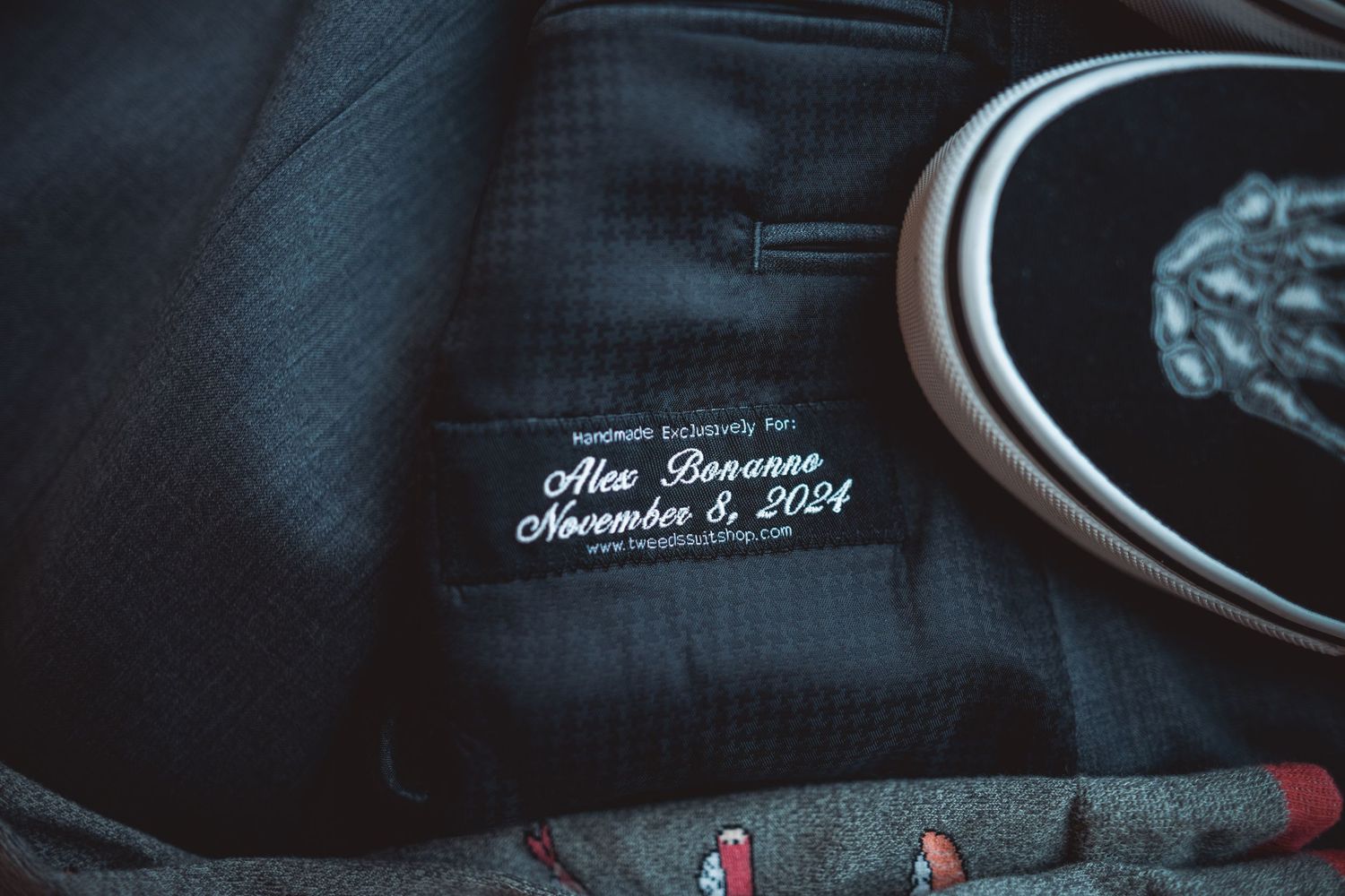 Close-up detail of embroidered wedding date on dark formal attire.