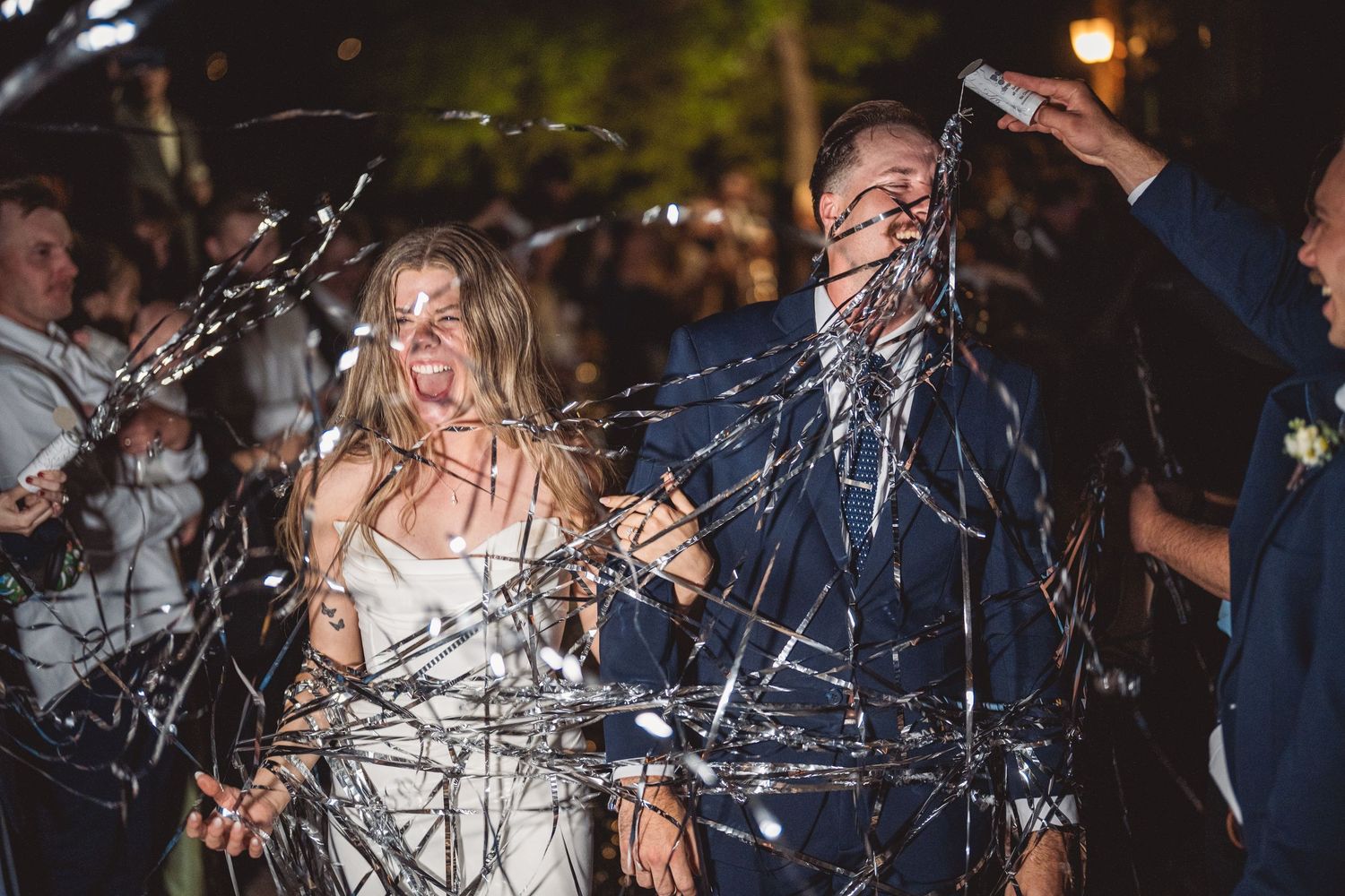Wedding party celebrates with sparklers during evening reception.