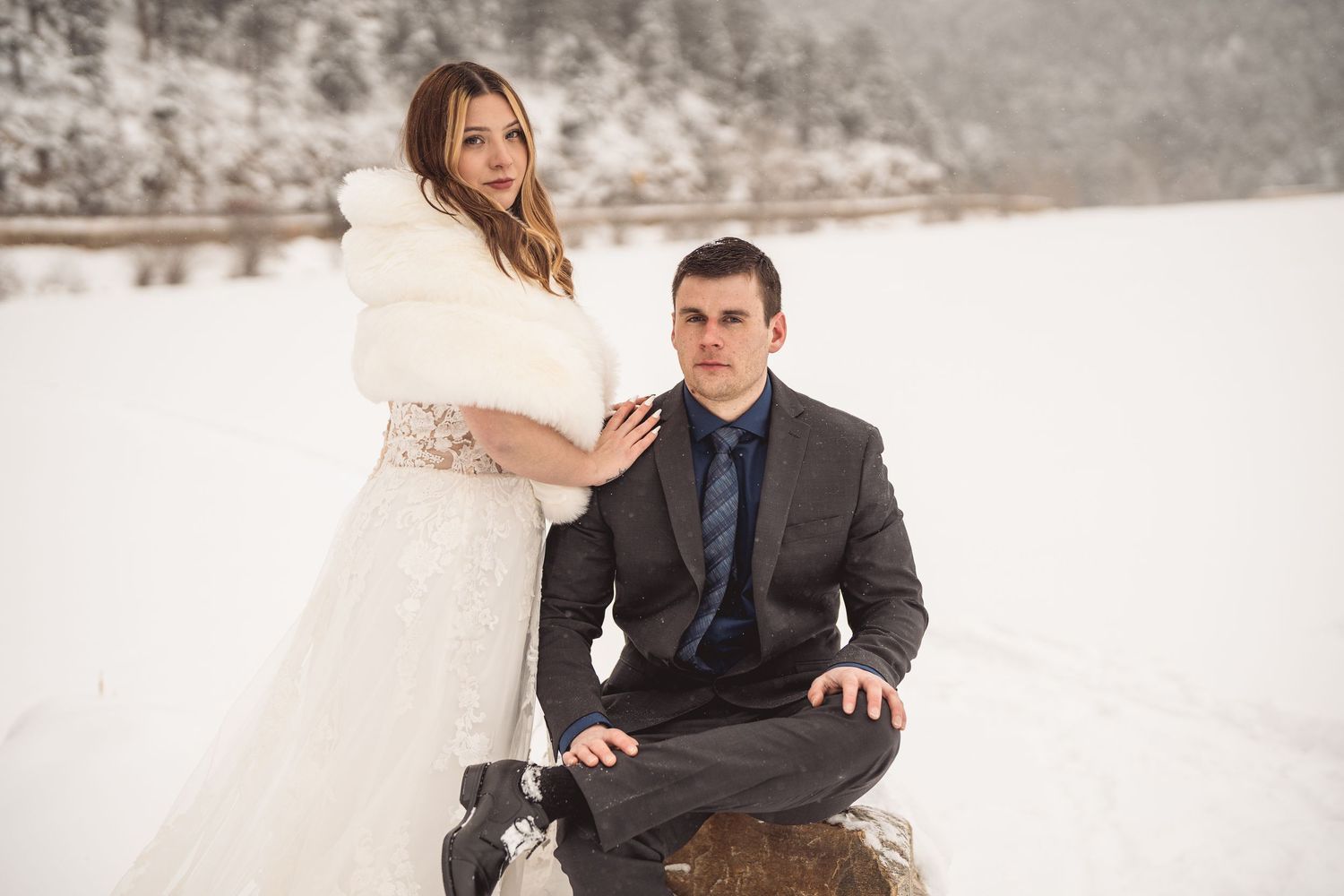 A winter wedding photoshoot with snowy mountain backdrop.
