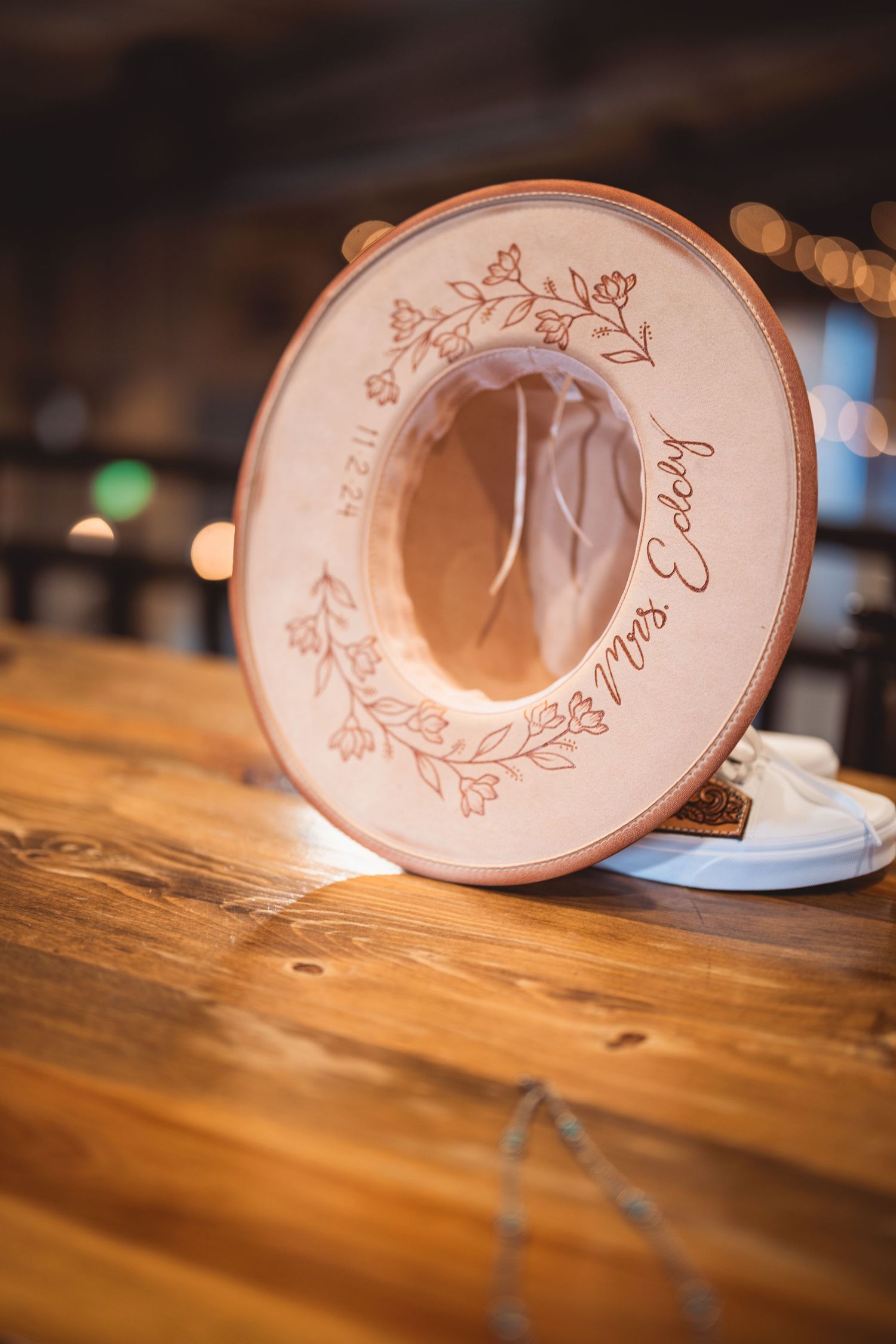 Pink engraved wedding cups arranged on a rustic wooden surface.